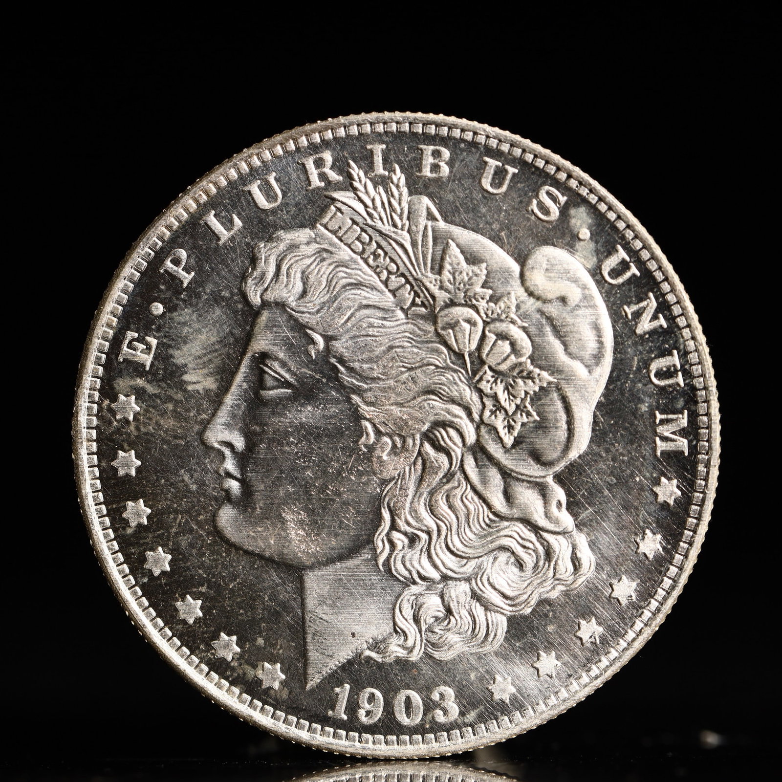 USA Morgan Dollar 1903 Coin: Obv: profile bust with date below and E PLURIBUS UNUM legend and stars around. Rev: eagle with In God we trust above within wreath with UNITED STATES OF AMERICA ONE DOLLAR legend. IN GOD WE TRUST / LI