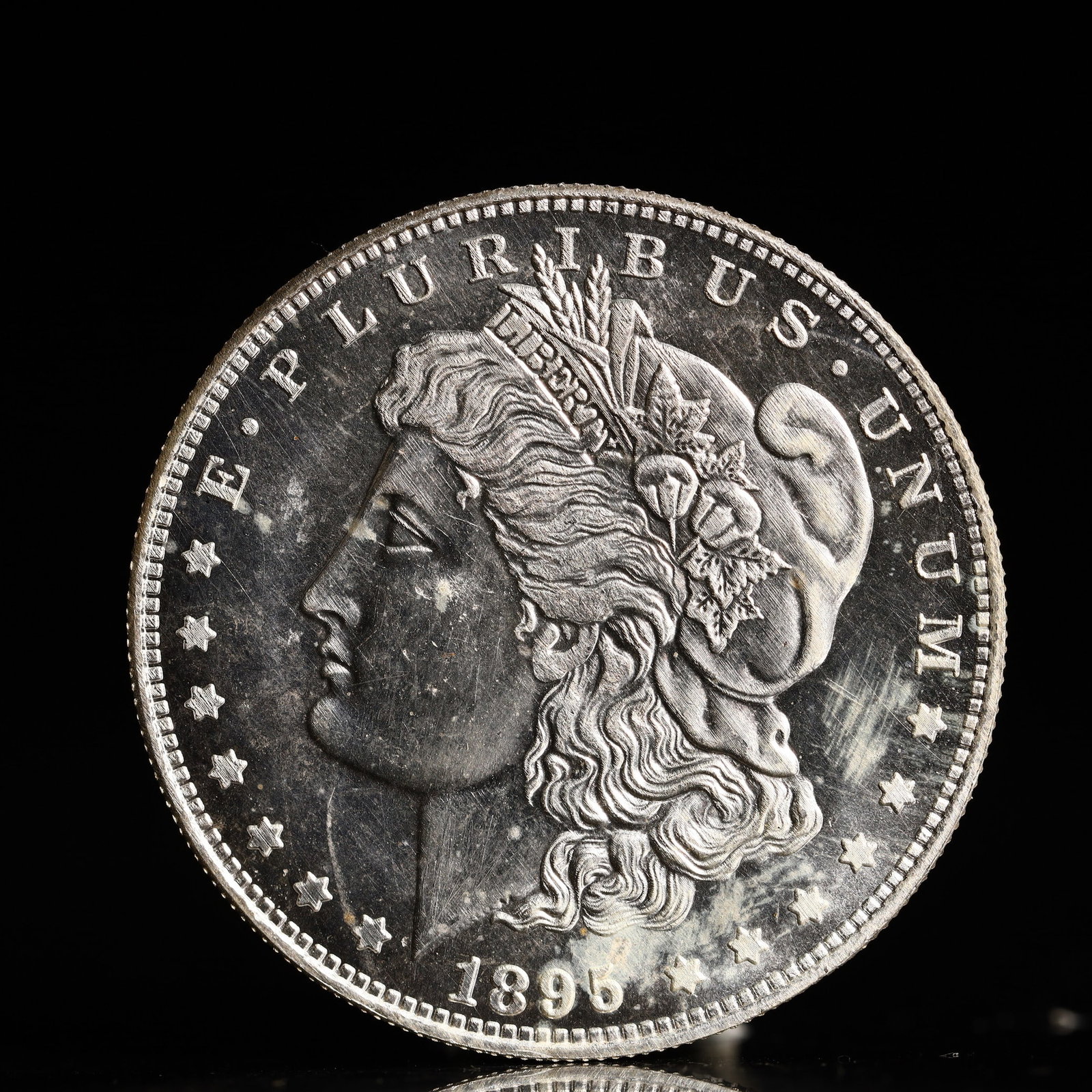 USA Morgan Dollar 1895 Coin: Obv: profile bust with date below and E PLURIBUS UNUM legend and stars around. Rev: eagle with In God we trust above within wreath with UNITED STATES OF AMERICA ONE DOLLAR legend. IN GOD WE TRUST / LI