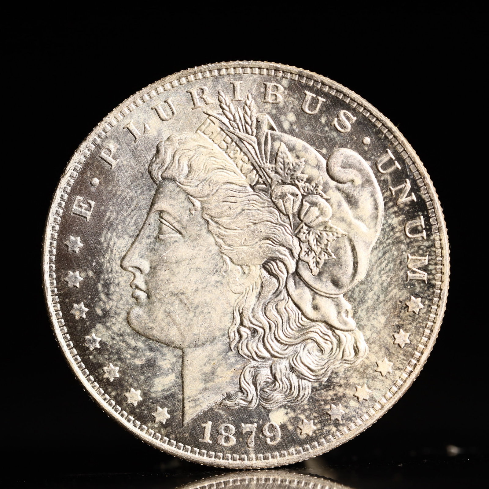 USA Morgan Dollar 1879 Coin: Obv: profile bust with date below and E PLURIBUS UNUM legend and stars around. Rev: eagle with In God we trust above within wreath with UNITED STATES OF AMERICA ONE DOLLAR legend. IN GOD WE TRUST / LI