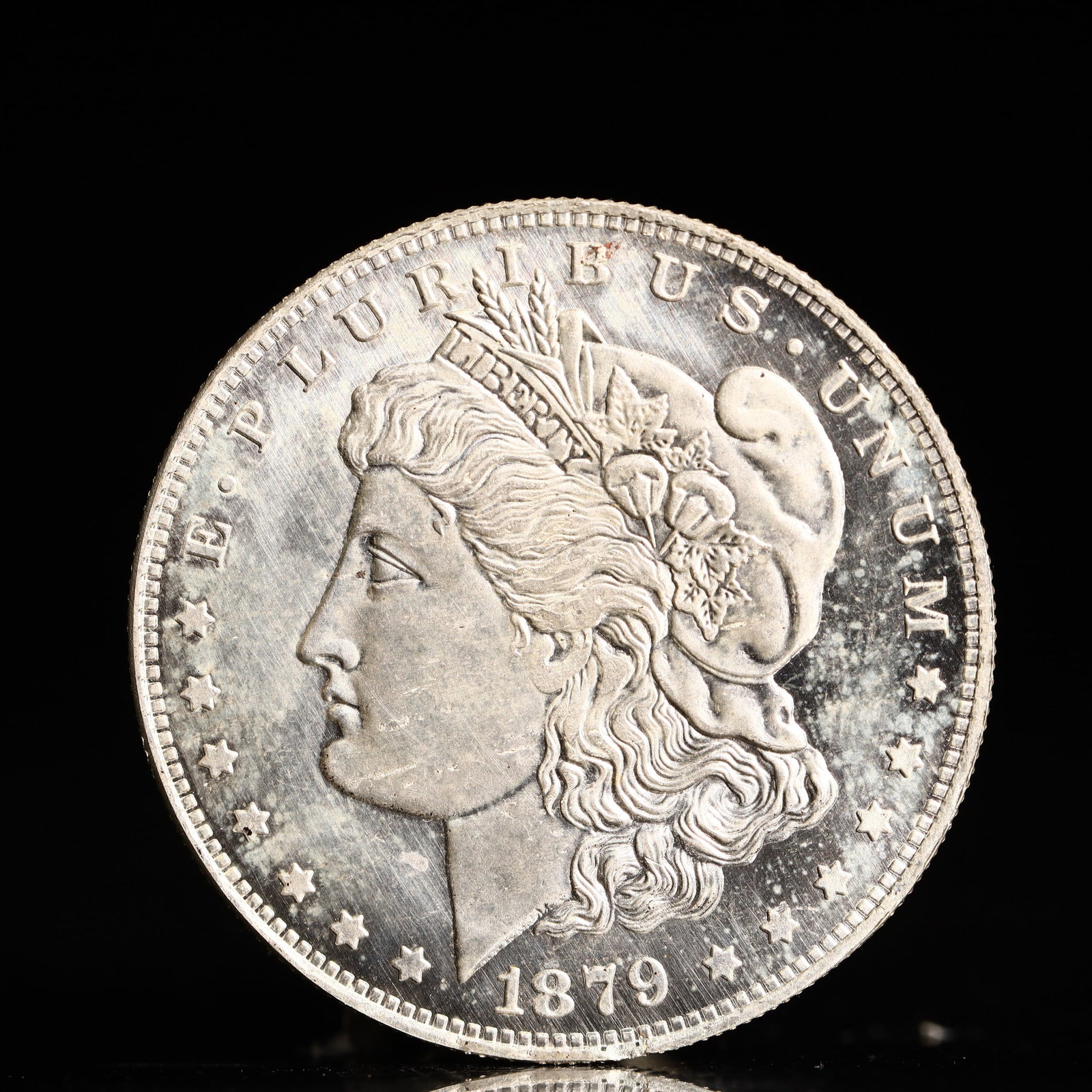USA Morgan Dollar 1879 Coin: Obv: profile bust with date below and E PLURIBUS UNUM legend and stars around. Rev: eagle with In God we trust above within wreath with UNITED STATES OF AMERICA ONE DOLLAR legend. IN GOD WE TRUST / LI