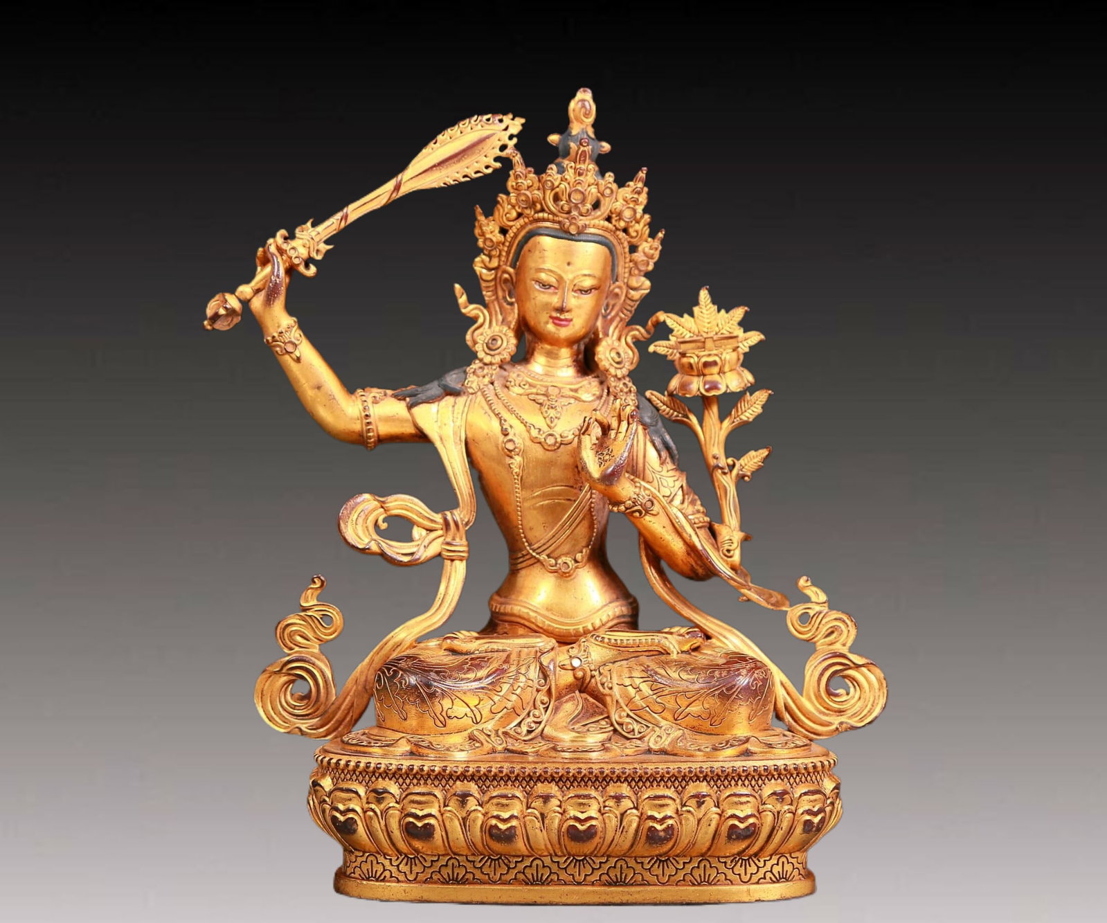 A solemn gilt bronze statue of Manjushri Bodhisattva: A solemn gilt bronze statue of Manjushri Bodhisattva,Kangxi seven-character mark,Qing Dynasty,China. Manjushri Bodhisattva wears a gorgeous crown adorned with gems,making it look more mysterious and