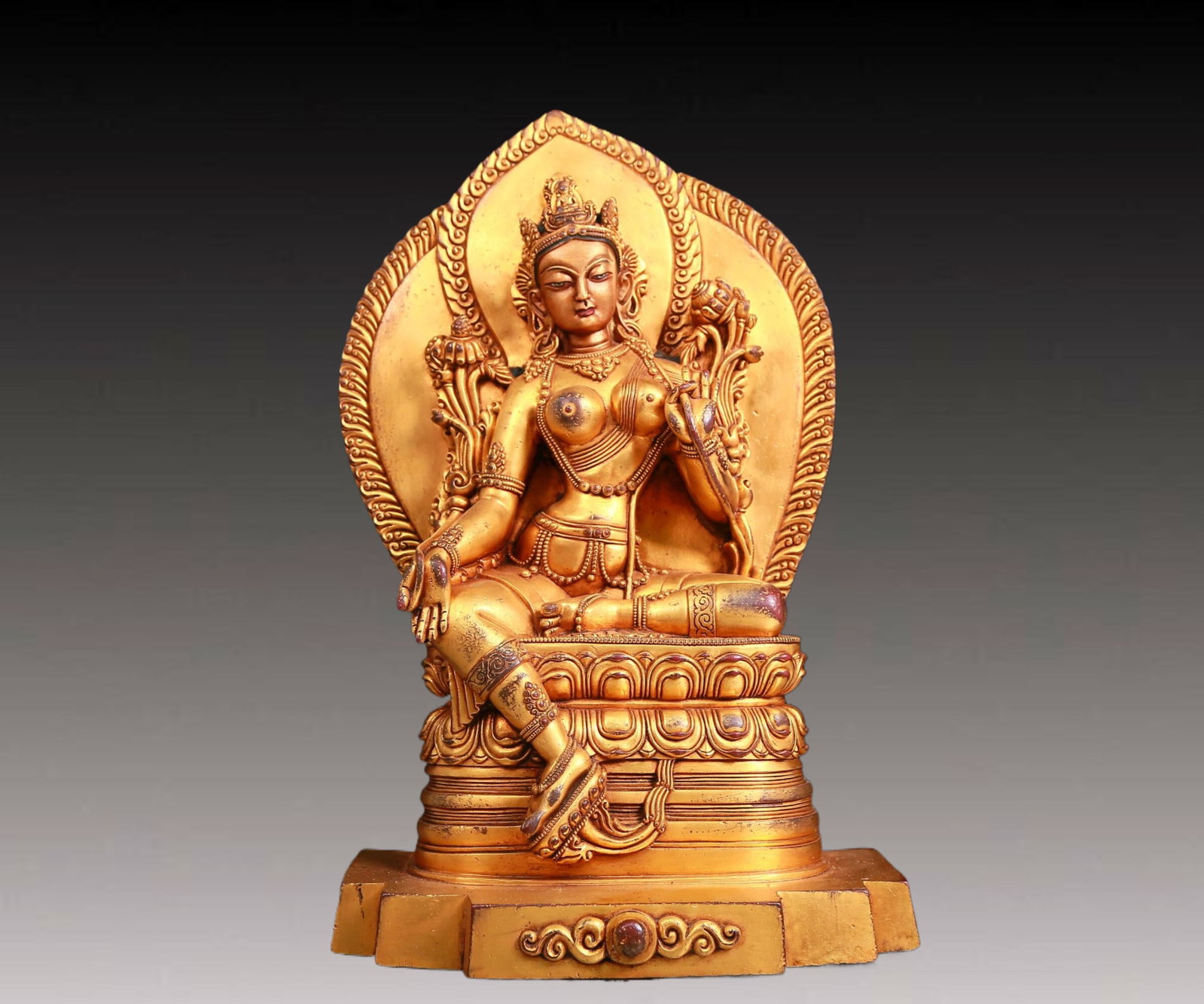 A solemn gilt bronze statue of green Tara: A solemn gilt-bronze green Tara statue with inscription,Ming Dynasty,China. Tara's posture is elegant,with a peaceful and compassionate expression. Her face is soft and A solemn,and her eyes are warm,
