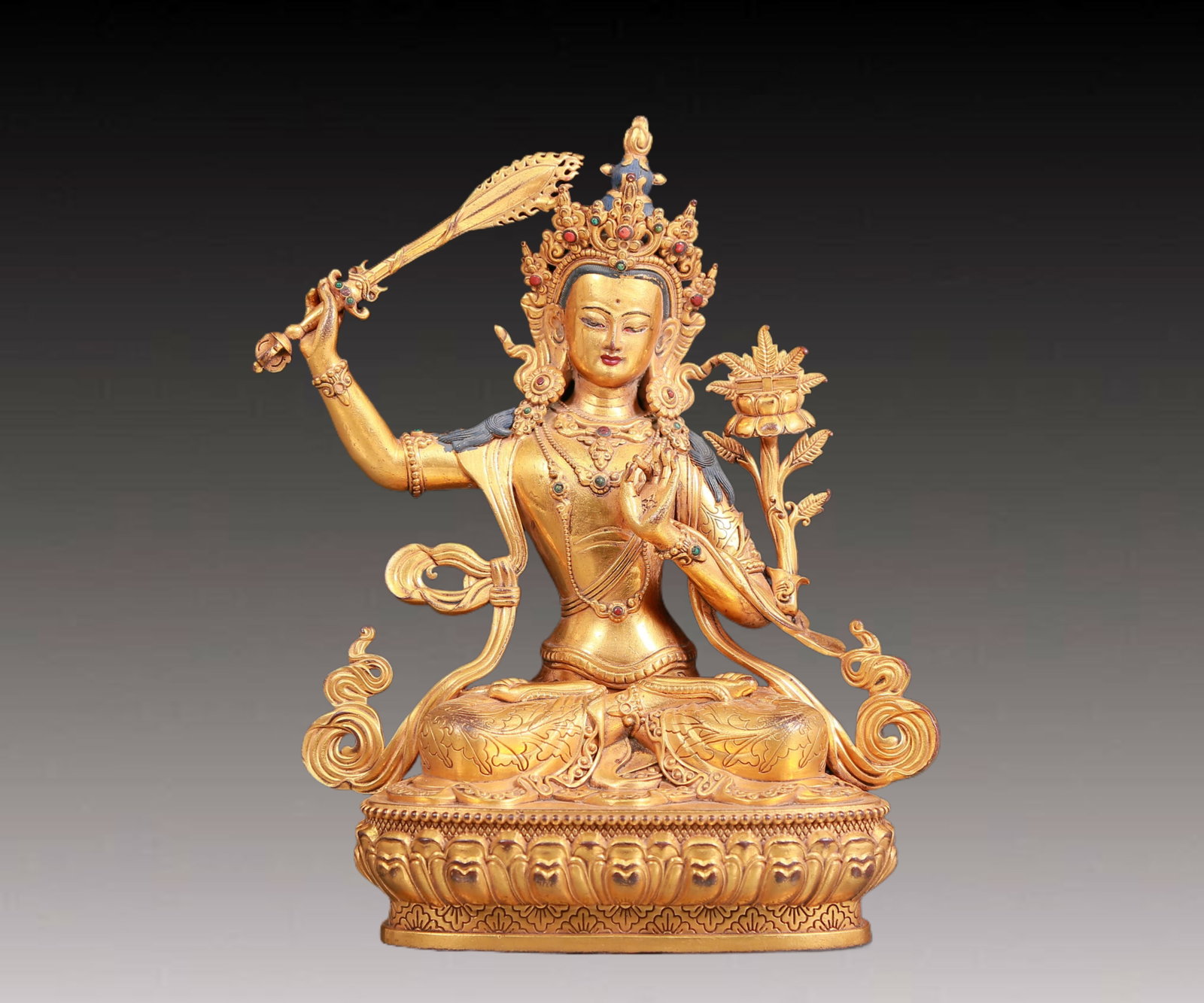 A solemn gilt bronze statue of Manjusri Bodhisattva inlaid gems: A solemn gilt bronze statue of Manjushri Bodhisattva inlaid with gems,Kangxi seven-character mark,Qing Dynasty,China. Manjushri Bodhisattva wears a gorgeous crown on his head,and the crown is dotted