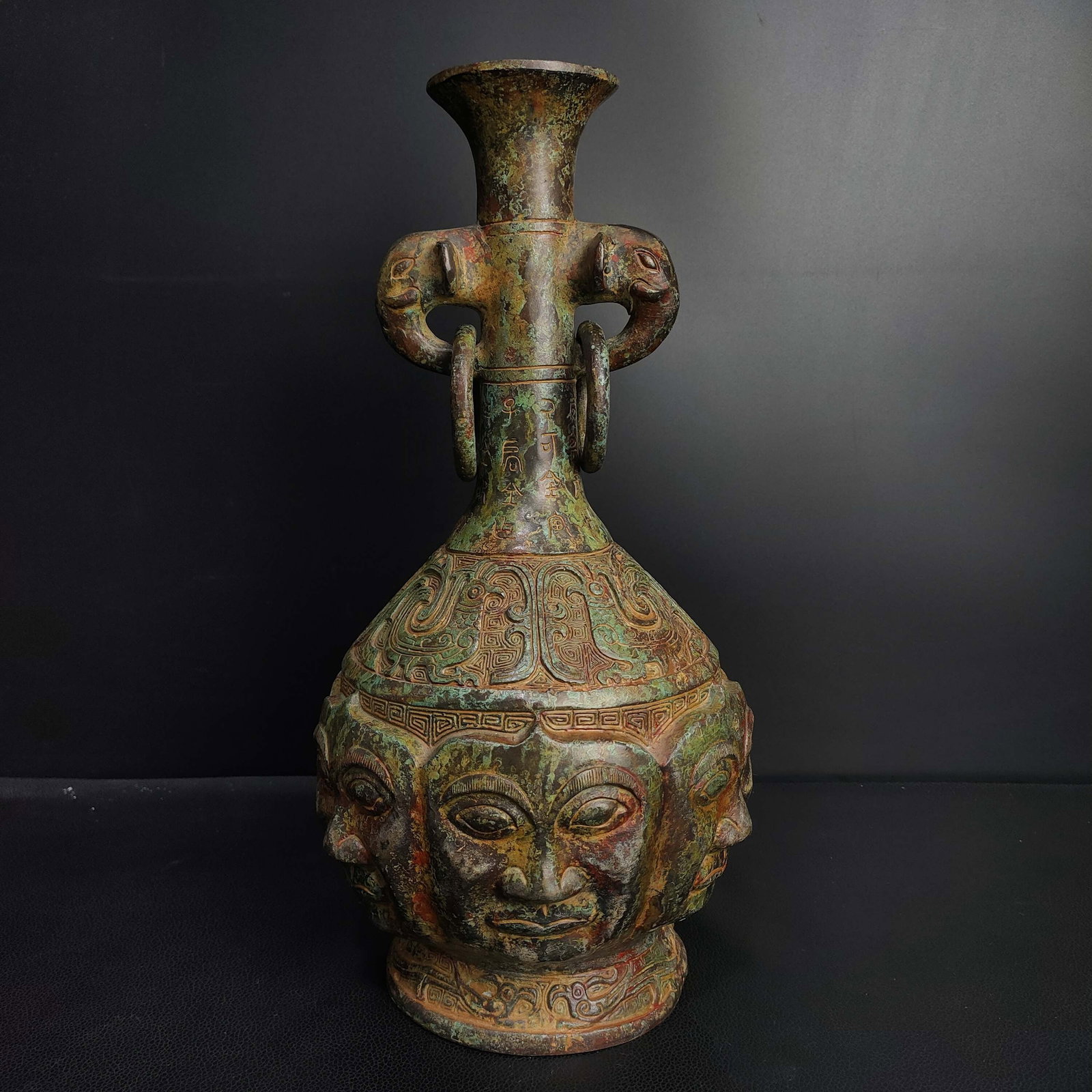 An Exquisite Bronze Figure-Face Pattern Elephant-Ears Vase,With Inscription: An Exquisite Bronze Figure-Face Pattern Elephant-Ears Vase,With Inscription,the Warring States period in China,Size:13.4inx7.1in,Weight:3100g,青铜人面纹象耳&#