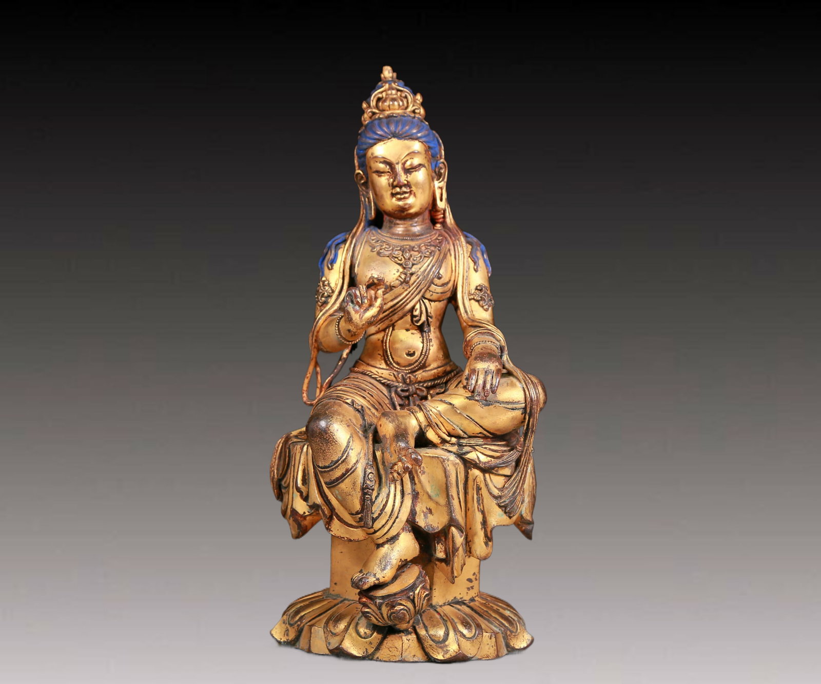 A solemn gilt bronze statue of Guanyin: A solemn gilt bronze statue of Guanyin,Kangxi mark,Qing Dynasty,China. Guanyin has a graceful posture and an expression of compassion and wisdom. Guanyin's gestures often have special meanings and are