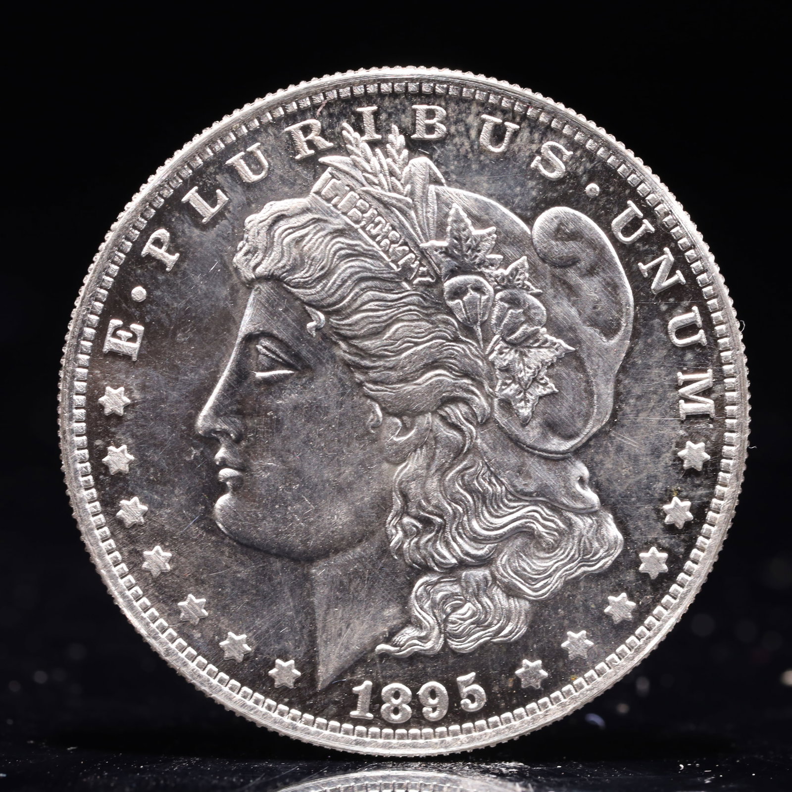 USA Morgan Dollar 1895 Coin: Obv: profile bust with date below and E PLURIBUS UNUM legend and stars around. Rev: eagle with In God we trust above within wreath with UNITED STATES OF AMERICA ONE DOLLAR legend. IN GOD WE TRUST /