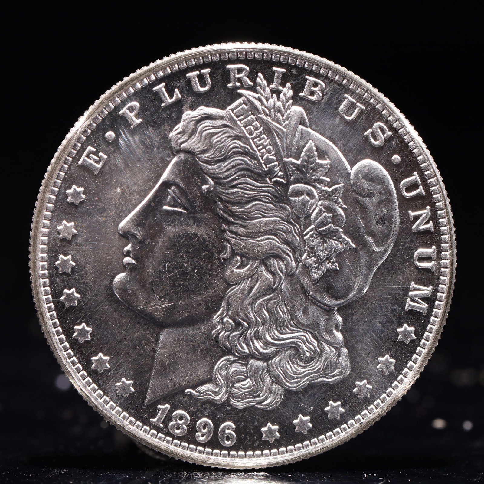 USA Morgan Dollar 1896 Coin: Obv: profile bust with date below and E PLURIBUS UNUM legend and stars around. Rev: eagle with In God we trust above within wreath with UNITED STATES OF AMERICA ONE DOLLAR legend. IN GOD WE TRUST / LI