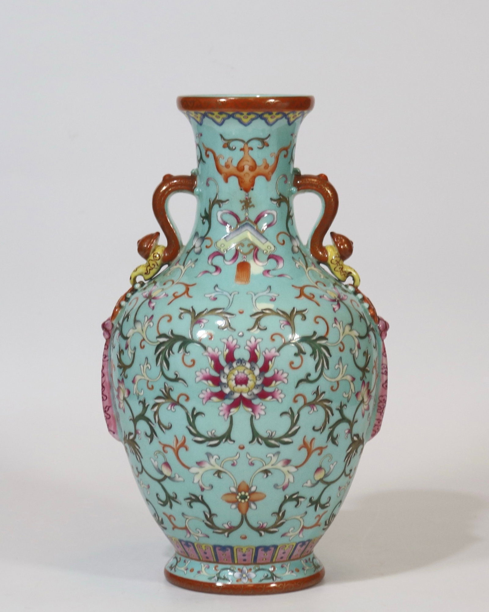 A fine turquoise green ground famille rose double-ruyi-handled vase with floral pattern: A fine turquoise green ground famille rose double-ruyi-handled vase with floral pattern, Qing Dynasty, China, with six-character Qianlong reign mark, Size:11.5inx6.3inA fine turquoise green ground fam