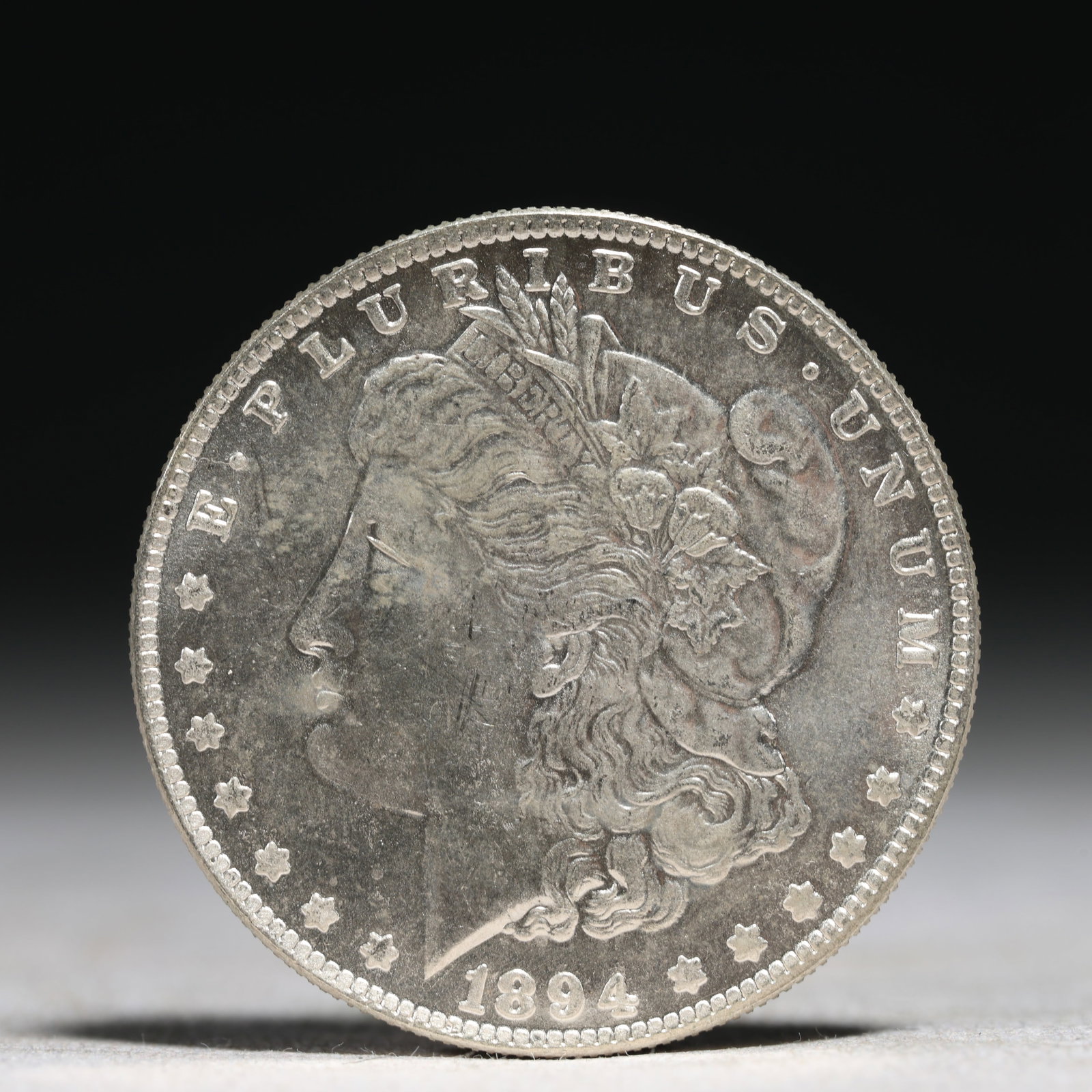 USA Morgan Dollar 1894 Coin: Obv: profile bust with date below and E PLURIBUS UNUM legend and stars around. Rev: eagle with In God we trust above within wreath with UNITED STATES OF AMERICA ONE DOLLAR legend. IN GOD WE TRUST / LI