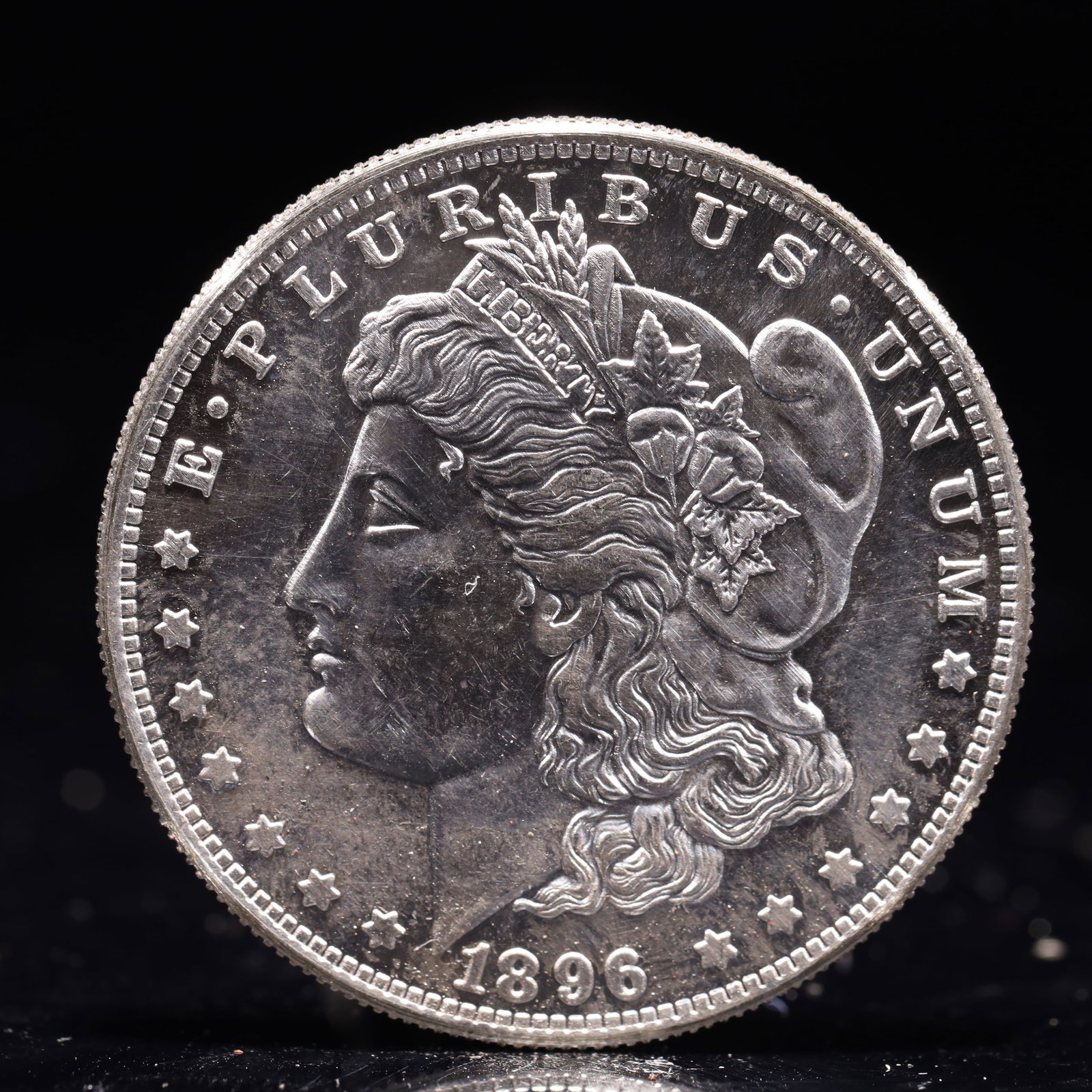 USA Morgan Dollar 1896 Coin: Obv: profile bust with date below and E PLURIBUS UNUM legend and stars around. Rev: eagle with In God we trust above within wreath with UNITED STATES OF AMERICA ONE DOLLAR legend. IN GOD WE TRUST / LI