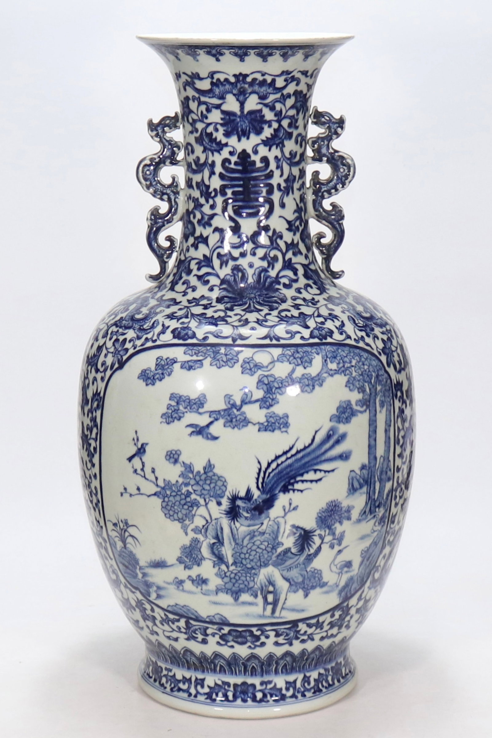 A fine blue and white large double-dragon-handled vase with reserved hundred birds paying homage to: A fine blue and white large double-dragon-handled vase with reserved hundred birds paying homage to phoenix panel, Qing Dynasty, China, with six-character Qianlong reign mark, Size:24.8inx7.9inA fine 