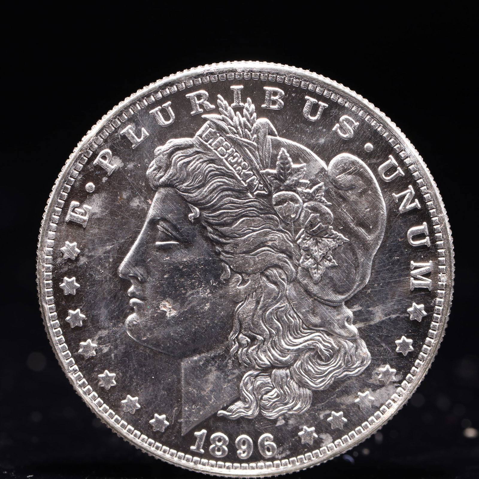 USA Morgan Dollar 1896 Coin: Obv: profile bust with date below and E PLURIBUS UNUM legend and stars around. Rev: eagle with In God we trust above within wreath with UNITED STATES OF AMERICA ONE DOLLAR legend. IN GOD WE TRUST / LI