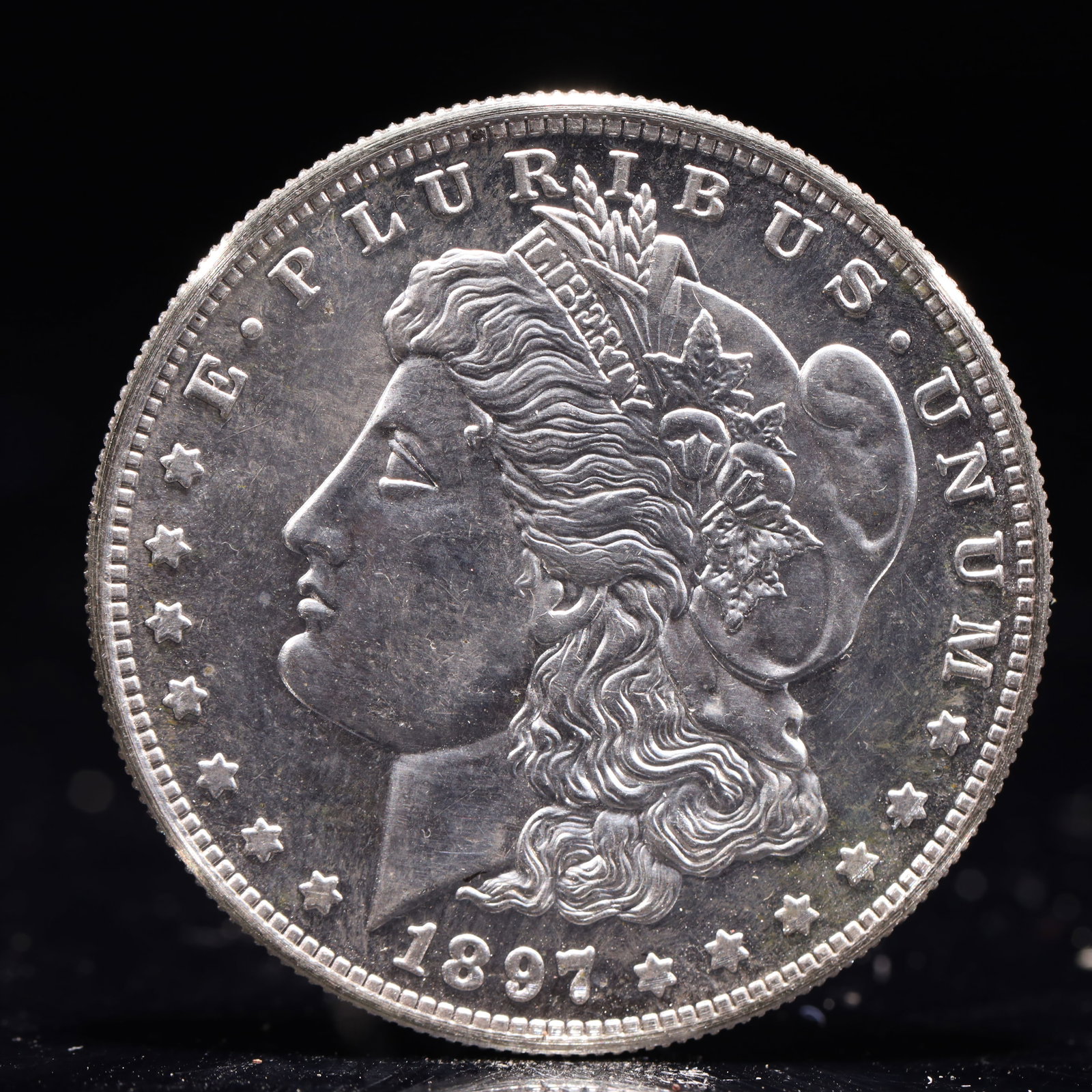 USA Morgan Dollar 1897 Coin: Obv: profile bust with date below and E PLURIBUS UNUM legend and stars around. Rev: eagle with In God we trust above within wreath with UNITED STATES OF AMERICA ONE DOLLAR legend. IN GOD WE TRUST / LI