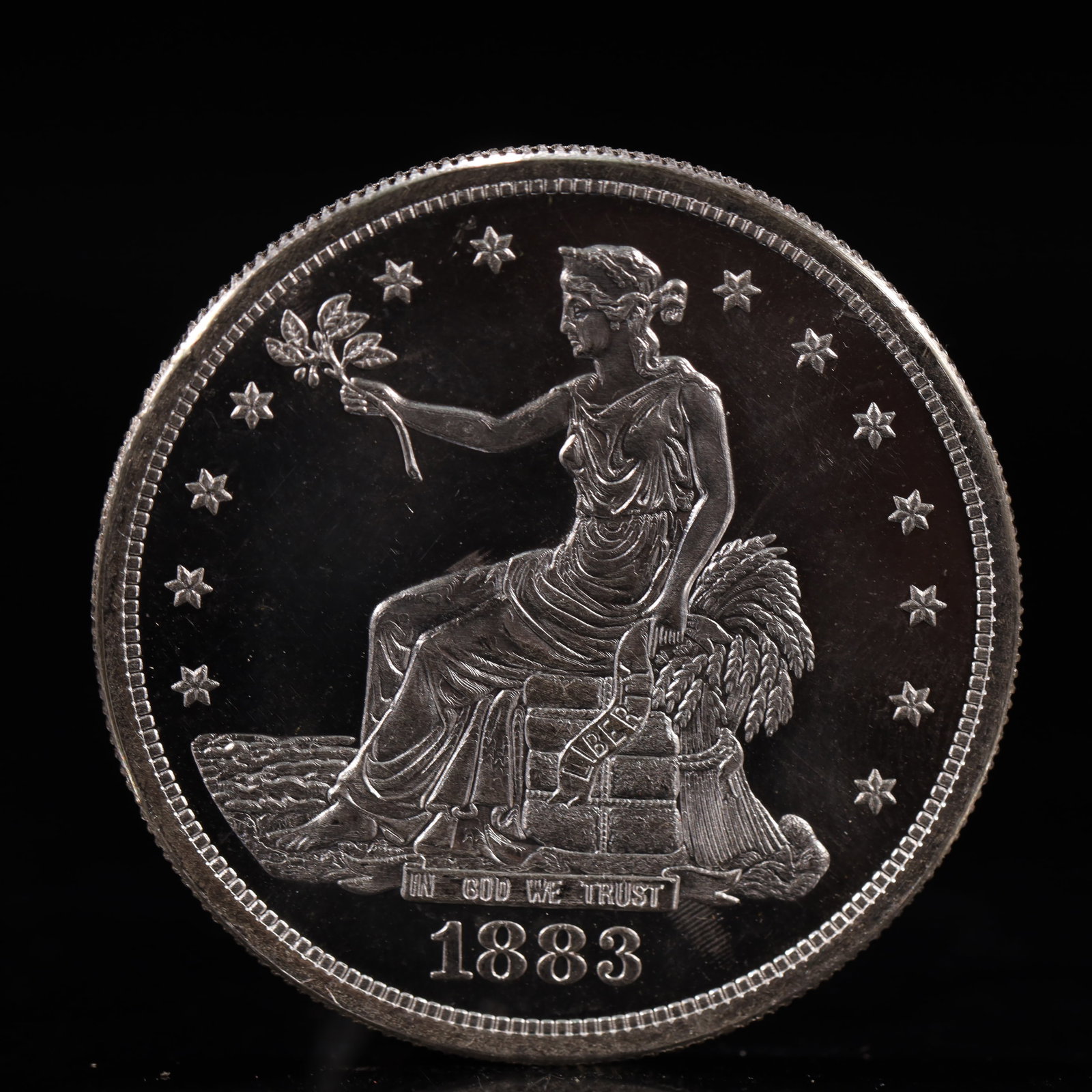 USA Trade Dollar 1883 Coin: American coin. Obverse: Liberty seated on a pedestal facing the sea to the left holding olive branches surrounded by 13 stars. IN GOD WE TRUST / LIBERTY / 1883. Reverse: An eagle holding branches