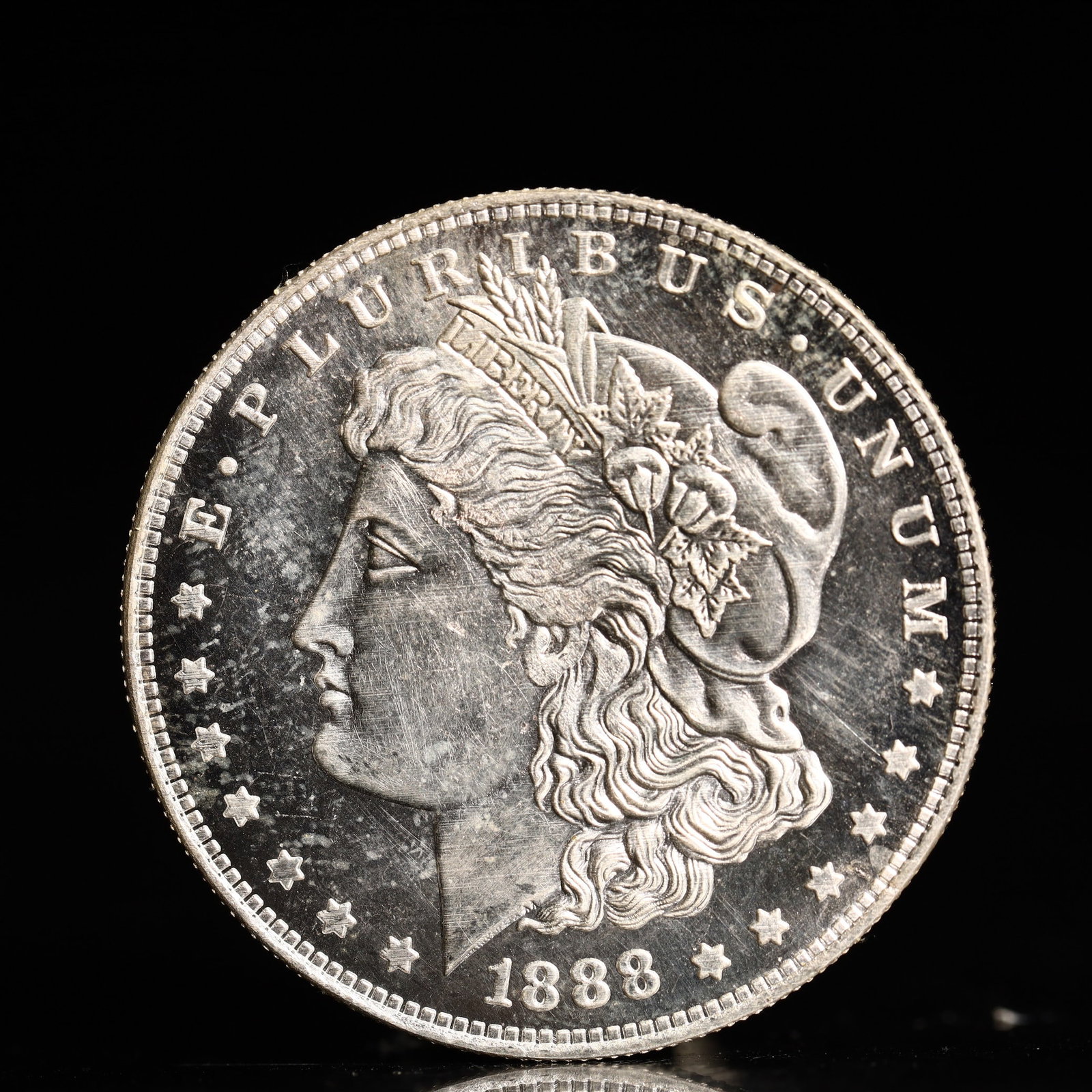 USA Morgan Dollar 1888 Coin: Obv: profile bust with date below and E PLURIBUS UNUM legend and stars around. Rev: eagle with In God we trust above within wreath with UNITED STATES OF AMERICA ONE DOLLAR legend. IN GOD WE TRUST / LI
