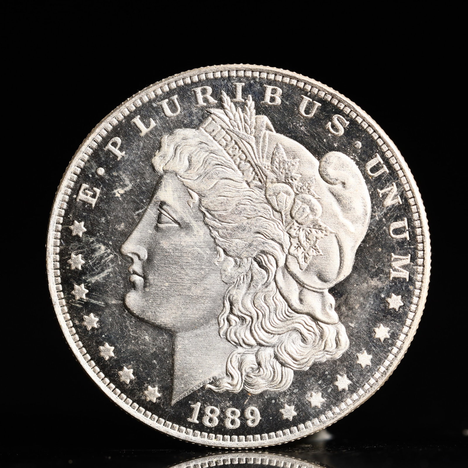 USA Morgan Dollar 1889 Coin: Obv: profile bust with date below and E PLURIBUS UNUM legend and stars around. Rev: eagle with In God we trust above within wreath with UNITED STATES OF AMERICA ONE DOLLAR legend. IN GOD WE TRUST / LI