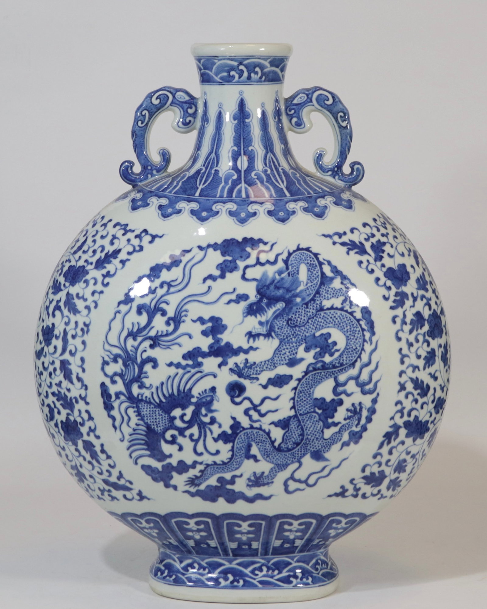 A fine blue and white scrolling floral dragon and phoenix moonflask: A fine blue and white scrolling floral dragon and phoenix moonflask, Qing Dynasty, China, with six-character Qianlong reign mark, Size:19.9inx14.2in 青花缠枝花卉