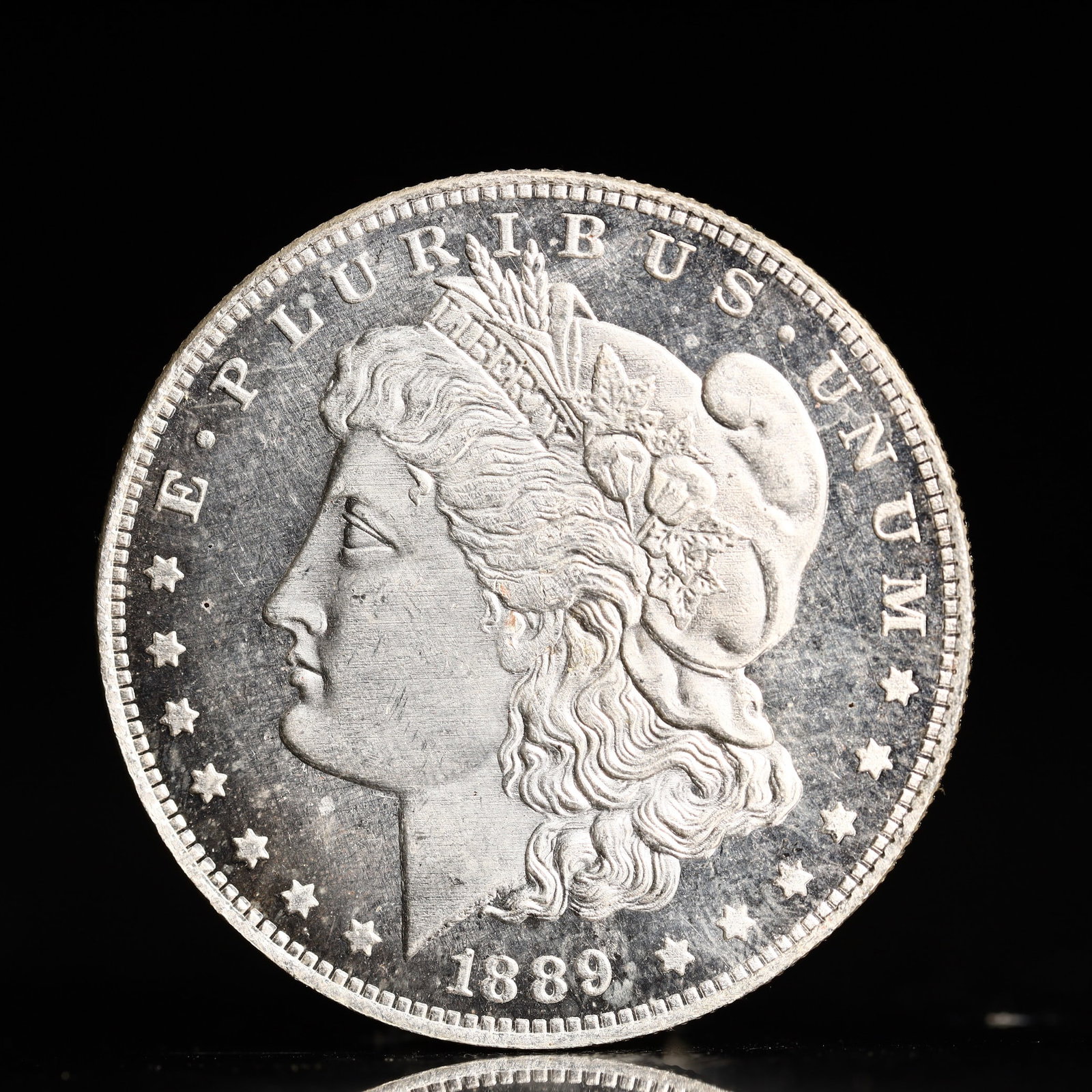 USA Morgan Dollar 1889 Coin: Obv: profile bust with date below and E PLURIBUS UNUM legend and stars around. Rev: eagle with In God we trust above within wreath with UNITED STATES OF AMERICA ONE DOLLAR legend. IN GOD WE TRUST / LI