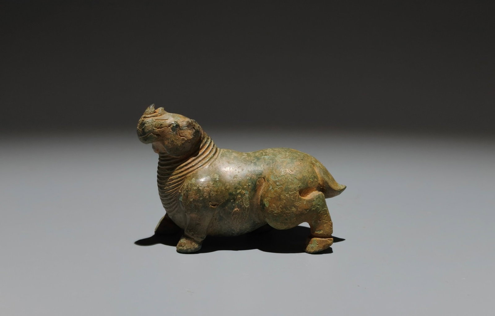 An Archaic Bronze Rhinoceros Ornament: An Archaic Bronze Rhinoceros Ornament,the Warring States period in China,Size:2.4inx3.3inx1.6in 青铜犀牛摆件,中国战国时期