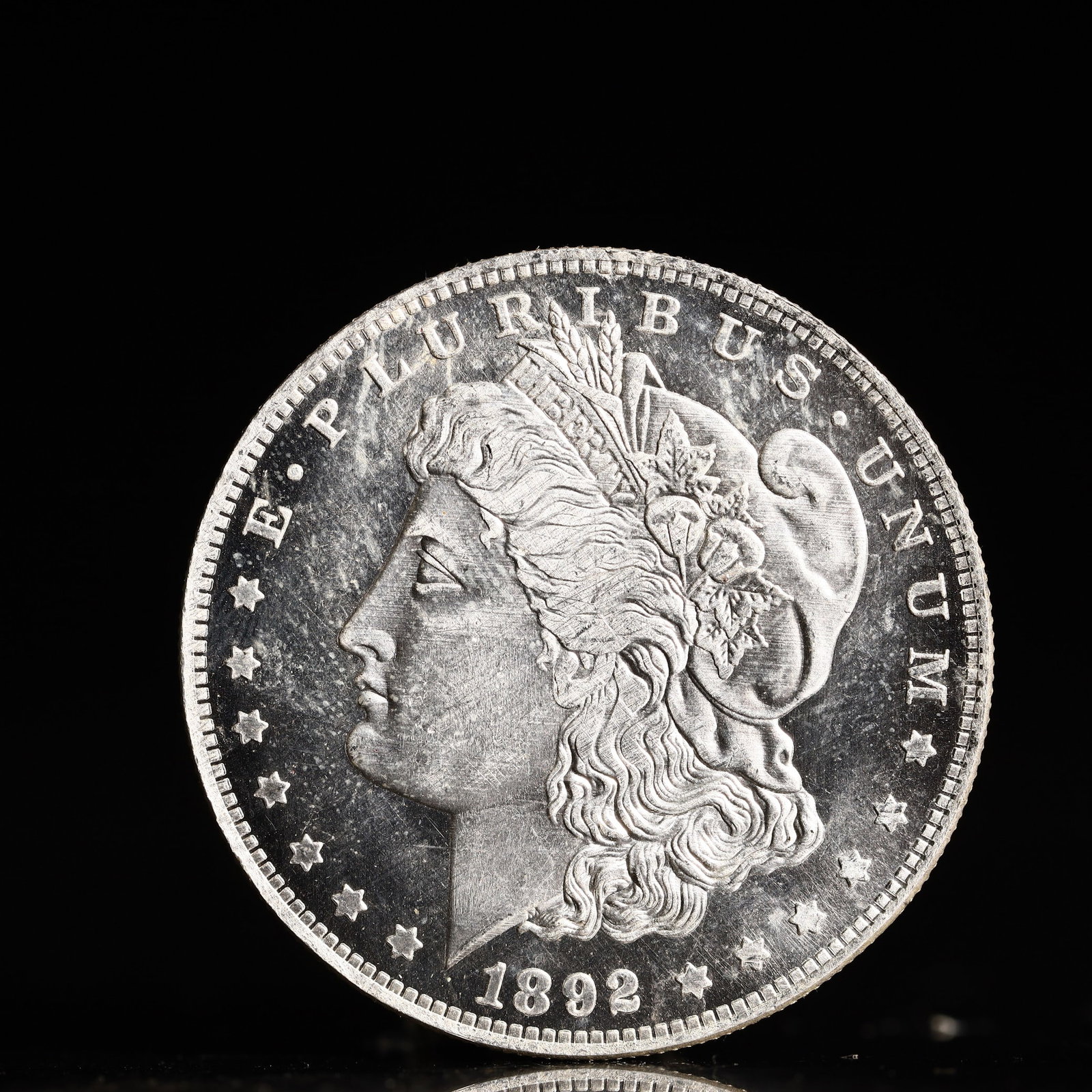 USA Morgan Dollar 1892 Coin: Obv: profile bust with date below and E PLURIBUS UNUM legend and stars around. Rev: eagle with In God we trust above within wreath with UNITED STATES OF AMERICA ONE DOLLAR legend. IN GOD WE TRUST / LI