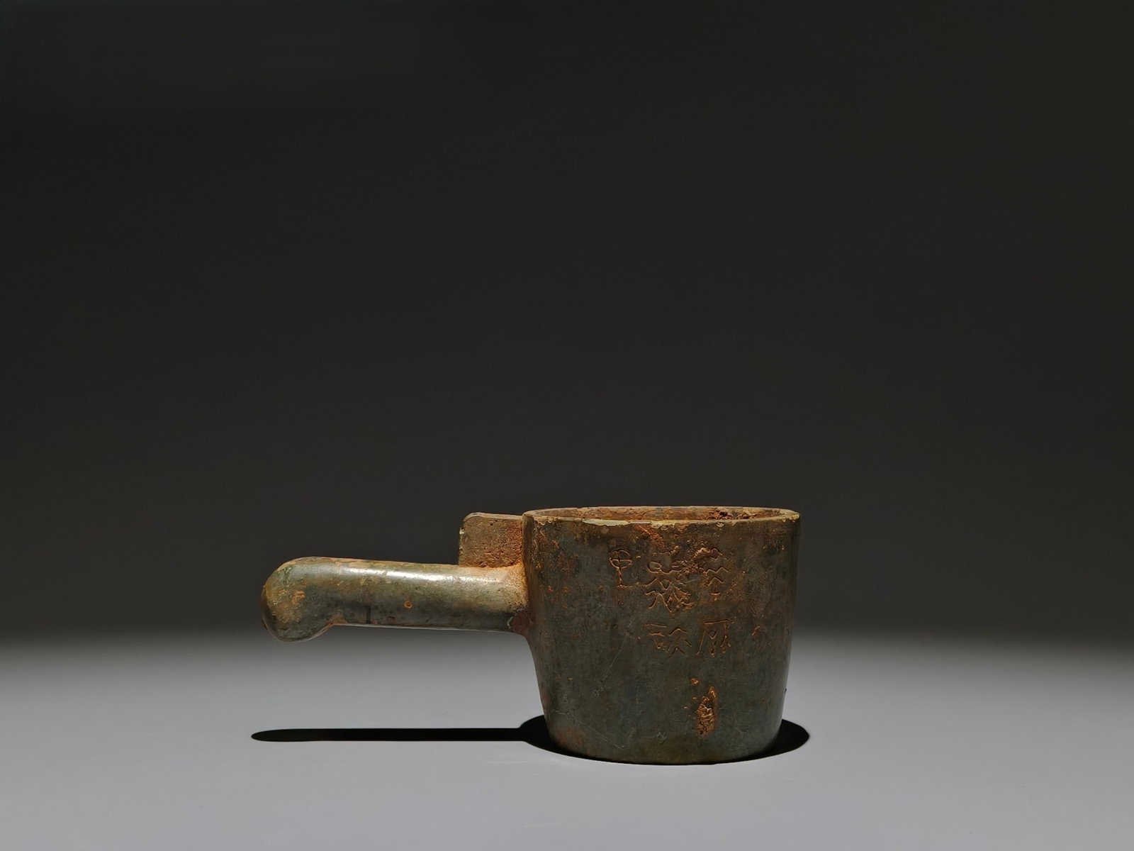 An Archaic Bronze Spoon,With Inscription: An Archaic Bronze Spoon,With Inscription,the Warring States period in China,Size:2.6inx5.9inx3.1in 青铜勺子,带铭文,中国战国时