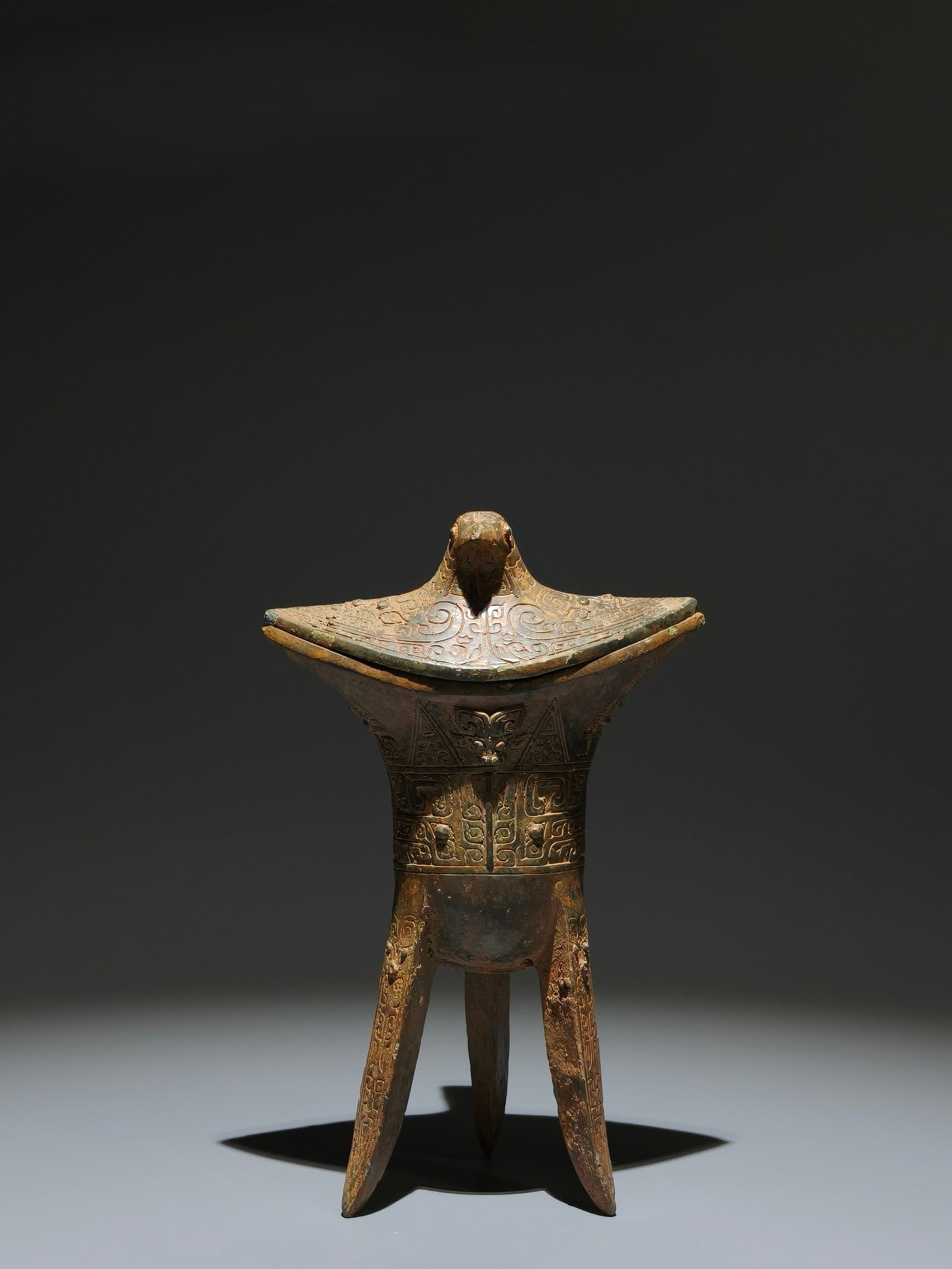 An Archaic Bronze Beast-Face Pattern Tripod Cup: An Archaic Bronze Beast-Face Pattern Tripod Cup,Western Zhou Dynasty,China,Size:8.3inx5.3inx3.5in 青铜兽面纹三足杯子,中国西Ø