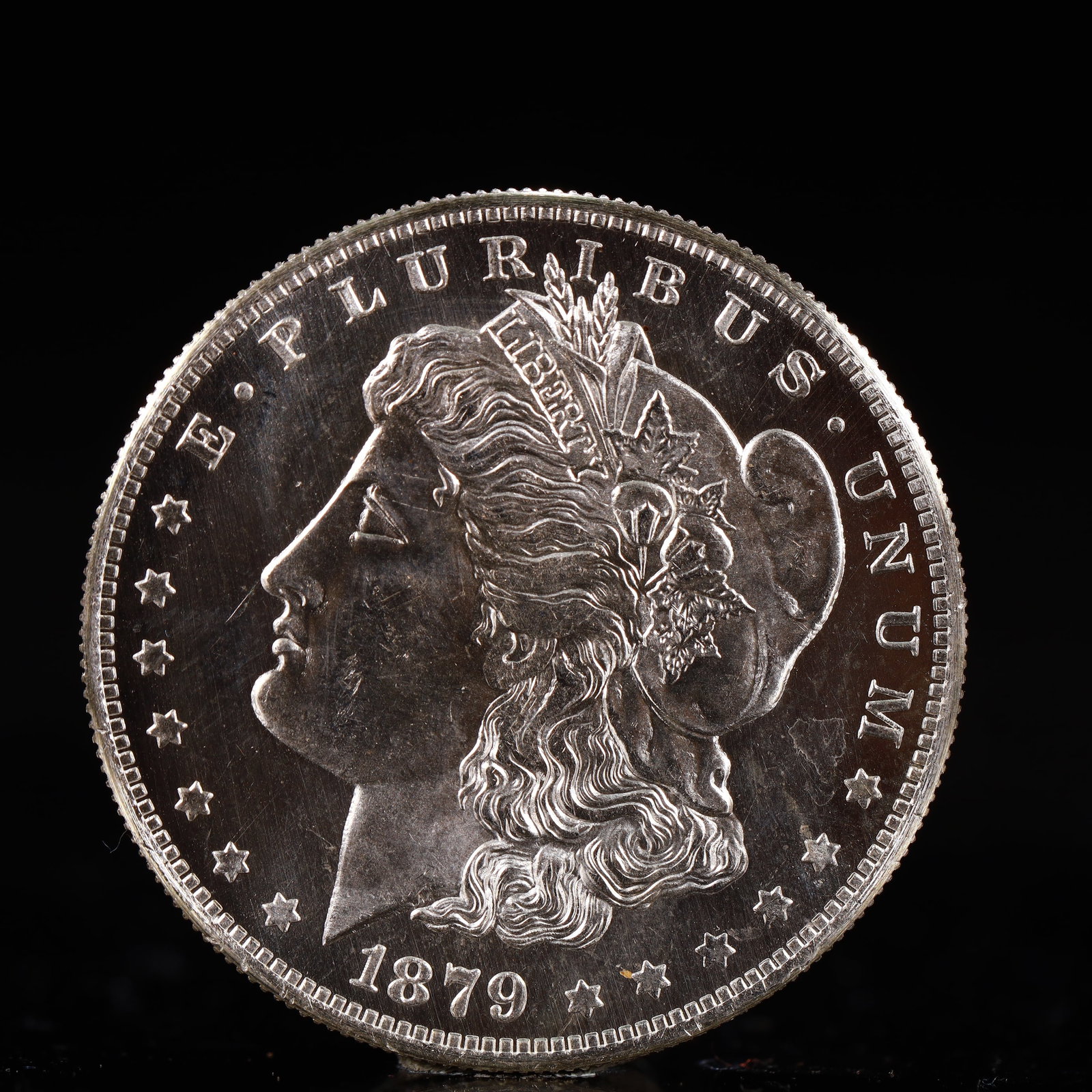 USA Morgan Dollar 1879 Coin: Obv: profile bust with date below and E PLURIBUS UNUM legend and stars around. Rev: eagle with In God we trust above within wreath with UNITED STATES OF AMERICA ONE DOLLAR legend. IN GOD WE TRUST / LI