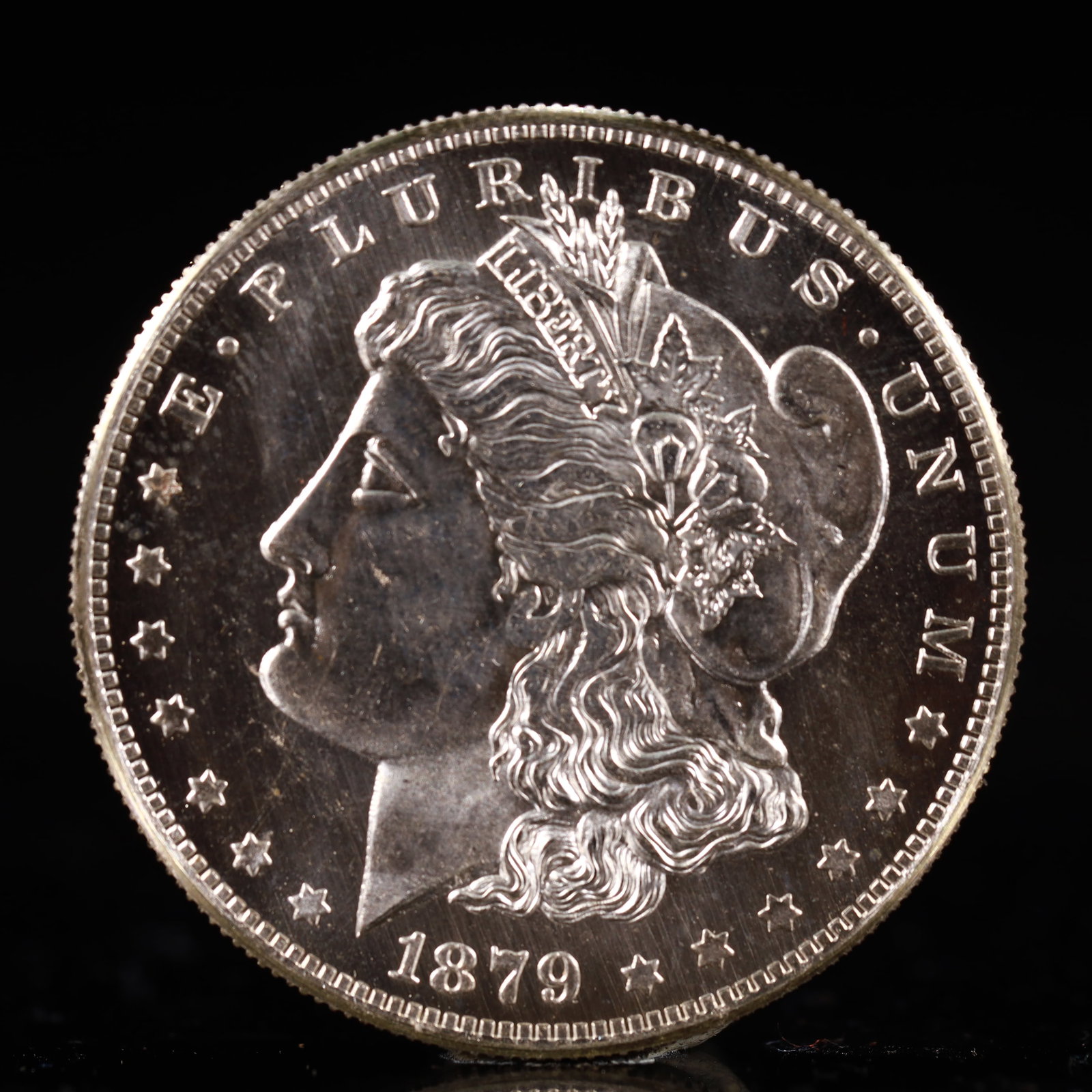 USA Morgan Dollar 1879 Coin: Obv: profile bust with date below and E PLURIBUS UNUM legend and stars around. Rev: eagle with In God we trust above within wreath with UNITED STATES OF AMERICA ONE DOLLAR legend. IN GOD WE TRUST / LI