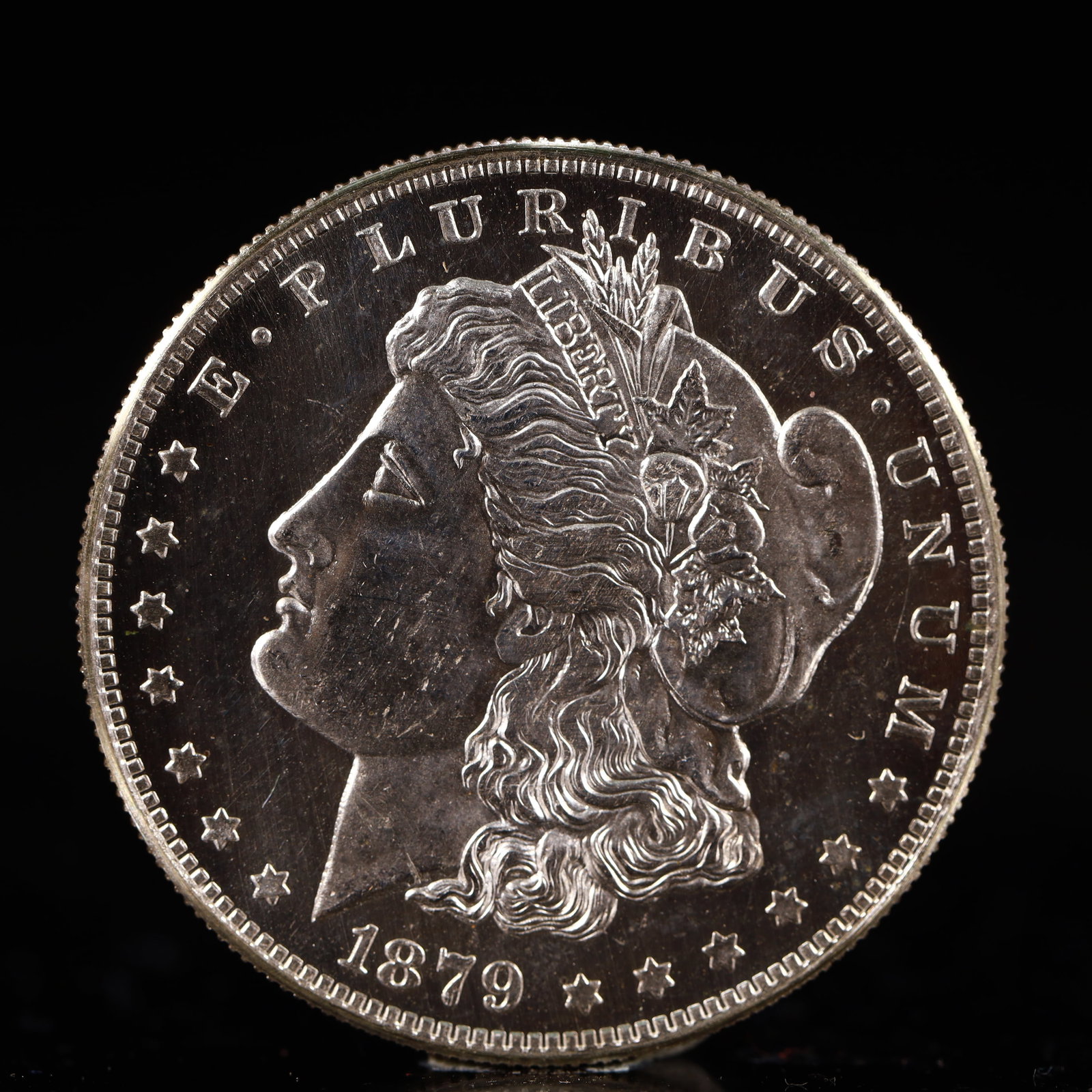 USA Morgan Dollar 1879 Coin: Obv: profile bust with date below and E PLURIBUS UNUM legend and stars around. Rev: eagle with In God we trust above within wreath with UNITED STATES OF AMERICA ONE DOLLAR legend. IN GOD WE TRUST / LI