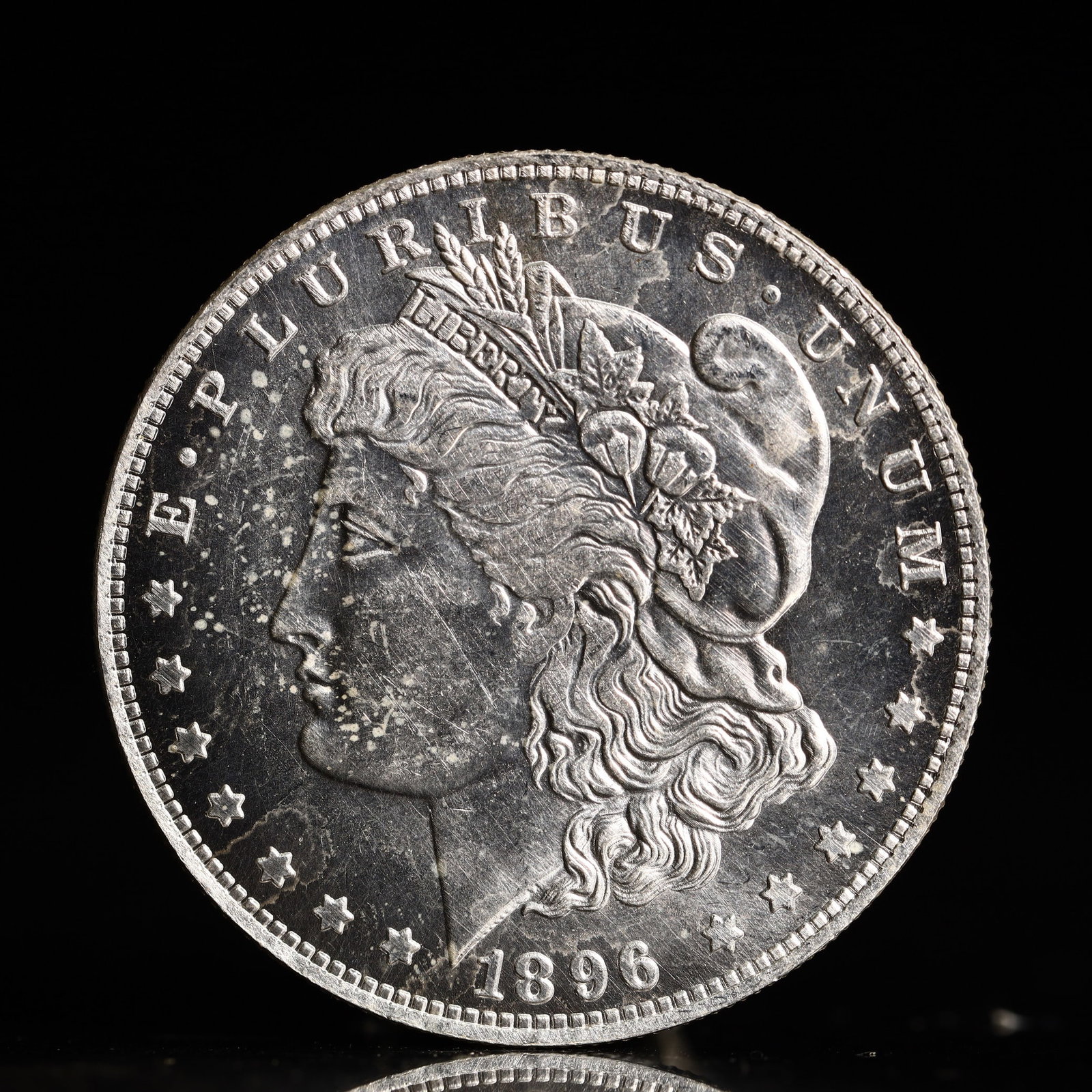 USA Morgan Dollar 1896 Coin: Obv: profile bust with date below and E PLURIBUS UNUM legend and stars around. Rev: eagle with In God we trust above within wreath with UNITED STATES OF AMERICA ONE DOLLAR legend. IN GOD WE TRUST /