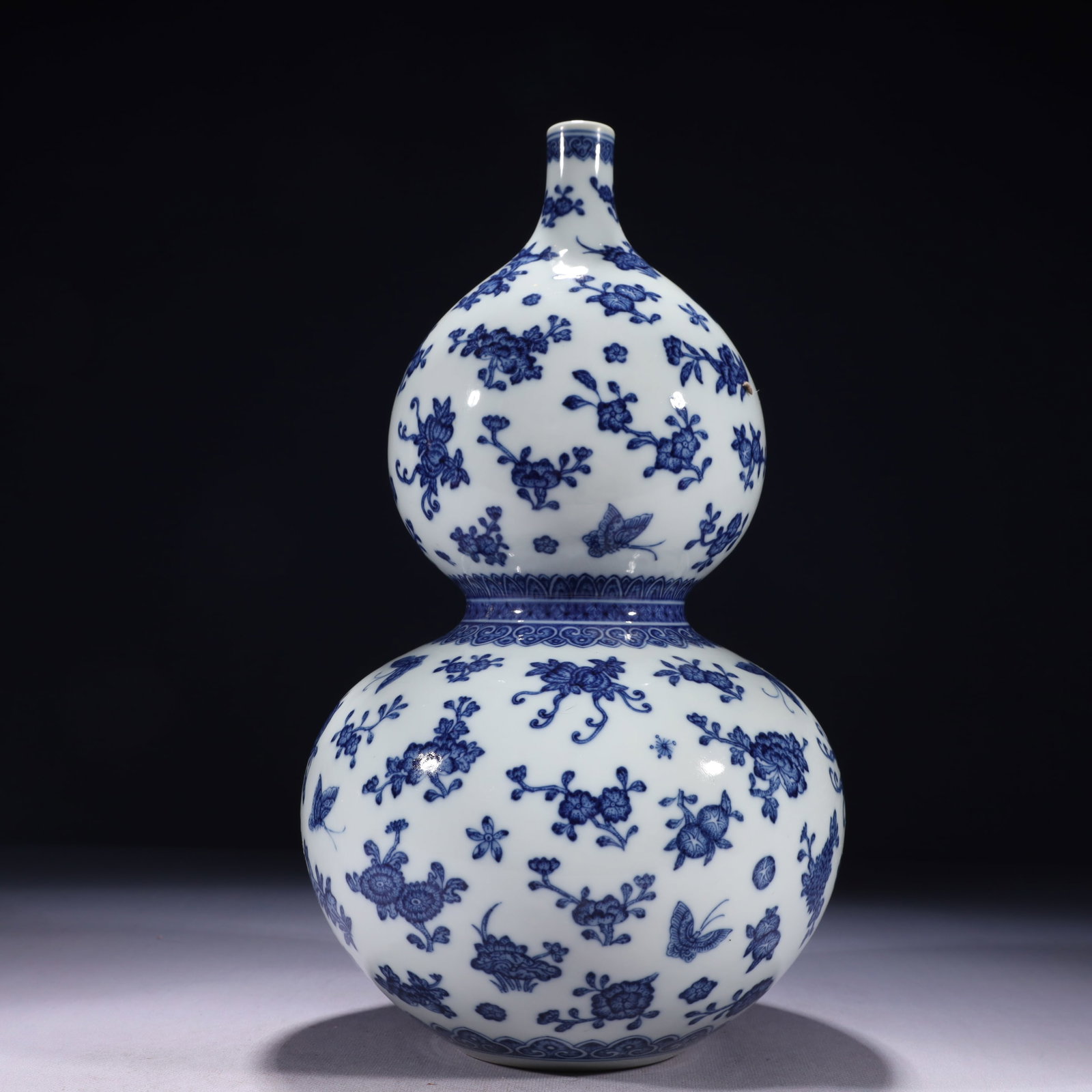 An Exquisite Blue and White Flower and Butterfly Pattern Gourd-Shaped Vase: An Exquisite Blue and White Flower and Butterfly Pattern Gourd-Shaped Vase,Qing Dynasty,China,Qianlong Six-character Mark,Size:7.9inx14.2in,Weight:2550g 青花花卉蝴蝶