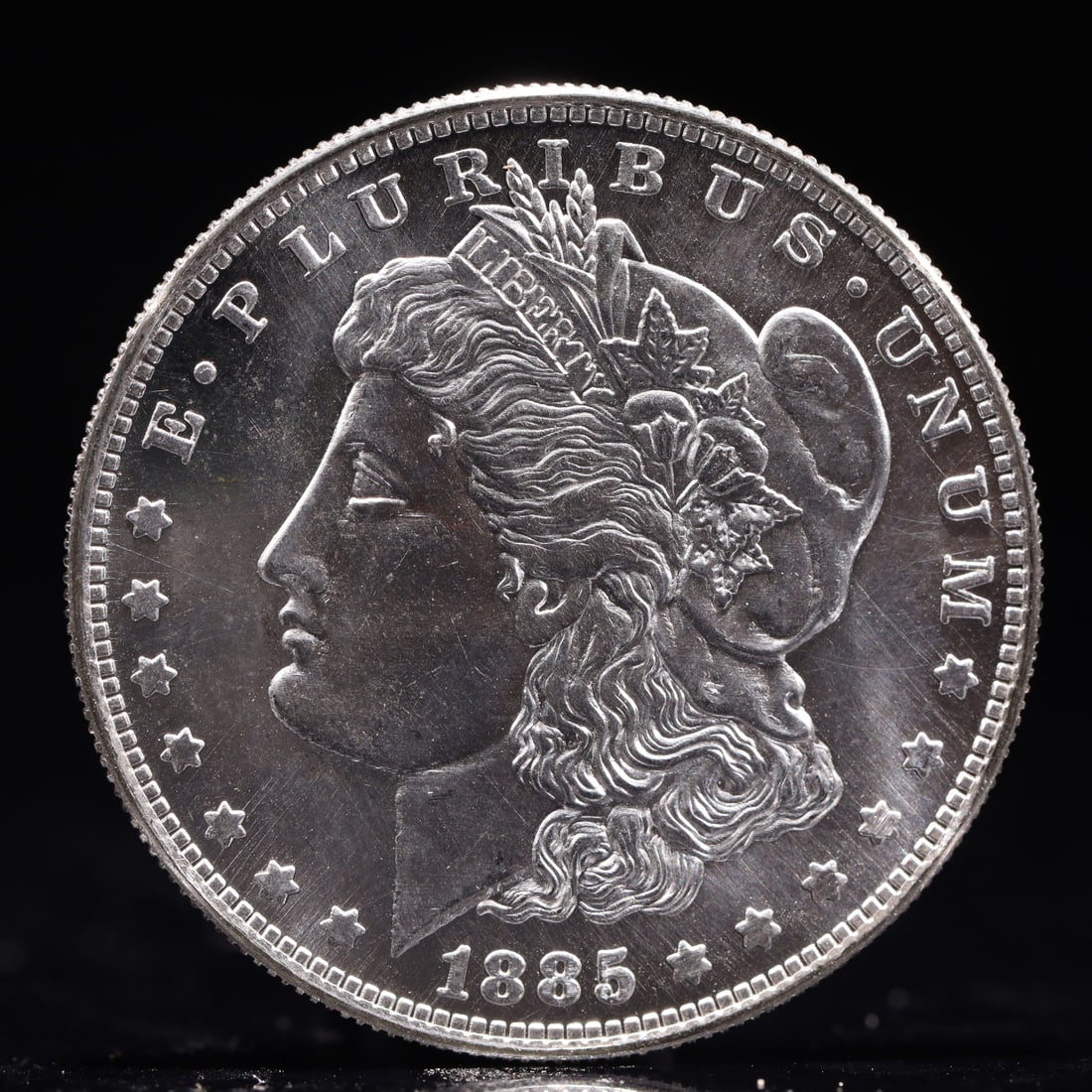 USA Morgan Dollar 1885 Coin: Obv: profile bust with date below and E PLURIBUS UNUM legend and stars around. Rev: eagle with In God we trust above within wreath with UNITED STATES OF AMERICA ONE DOLLAR legend. IN GOD WE TRUST / LI