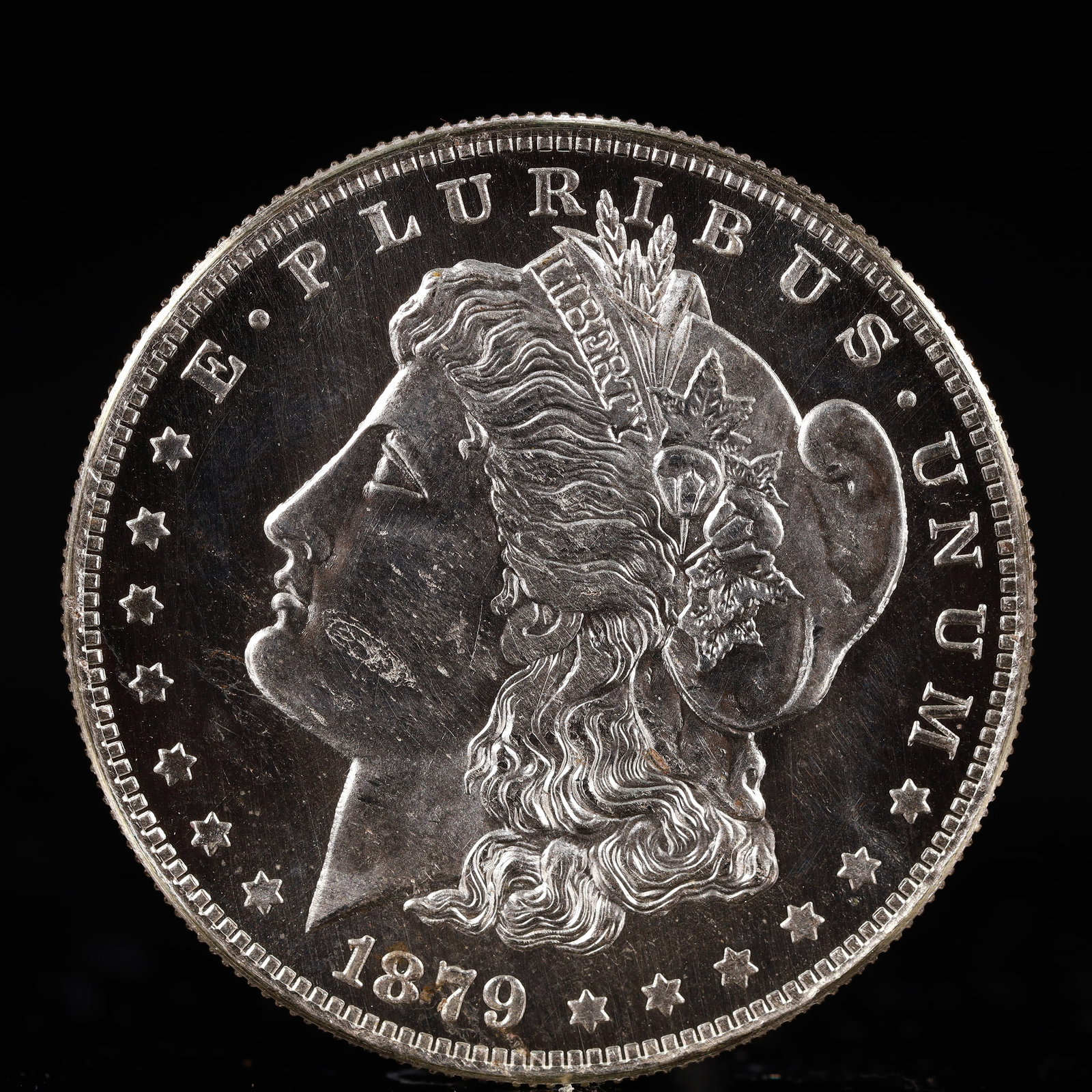 USA Morgan Dollar 1879 Coin: Obv: profile bust with date below and E PLURIBUS UNUM legend and stars around. Rev: eagle with In God we trust above within wreath with UNITED STATES OF AMERICA ONE DOLLAR legend. IN GOD WE TRUST / LI