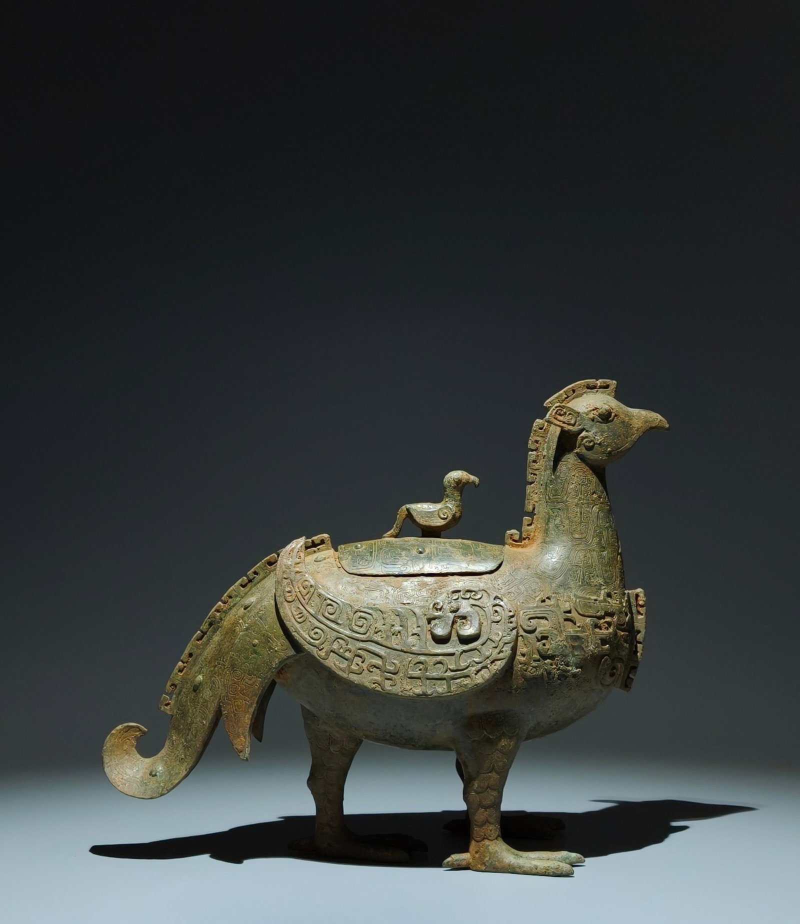 An Archaic Bronze Dragon Pattern ??-Shaped Tripod Food Vessel,With Inscription: An Archaic Bronze Dragon Pattern 鸟-Shaped Tripod Food Vessel,With Inscription,the Warring States period in China,Size:10.8inx12.6inx5.3in 青铜龙纹鸟形三