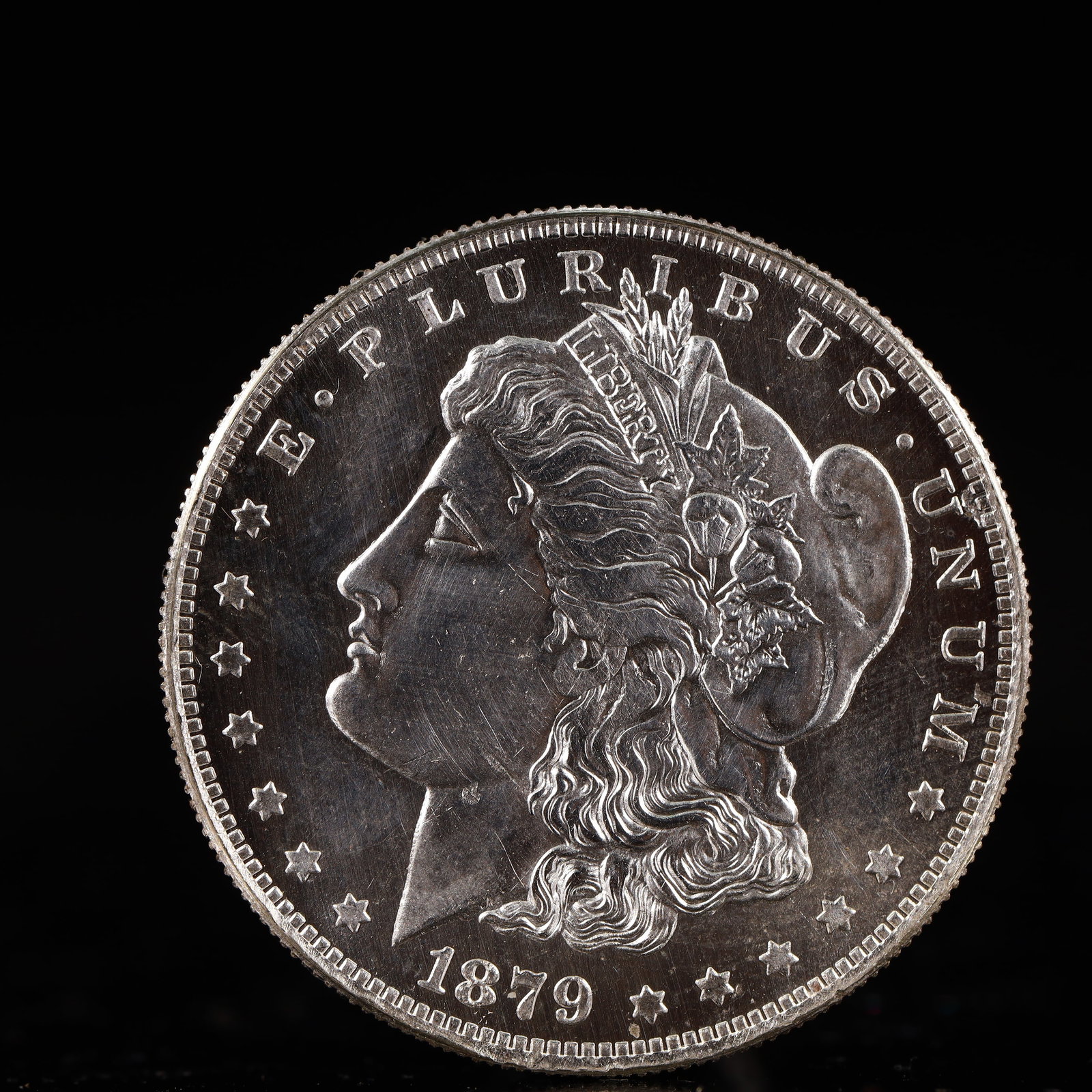 USA Morgan Dollar 1879 Coin: Obv: profile bust with date below and E PLURIBUS UNUM legend and stars around. Rev: eagle with In God we trust above within wreath with UNITED STATES OF AMERICA ONE DOLLAR legend. IN GOD WE TRUST / LI