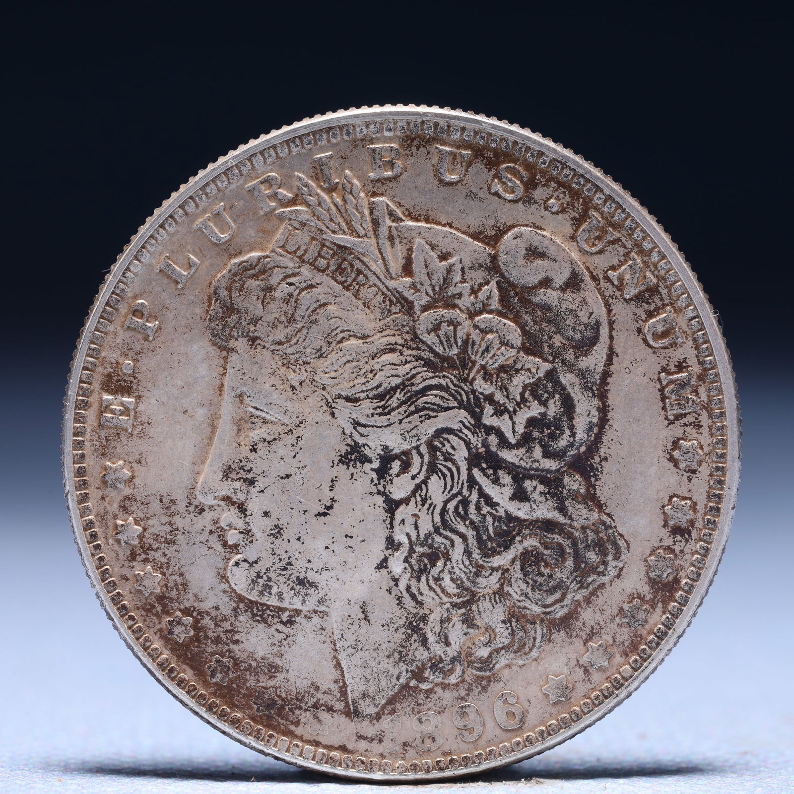 USA Morgan Dollar 1896 Coin: Obv: profile bust with date below and E PLURIBUS UNUM legend and stars around. Rev: eagle with In God we trust above within wreath with UNITED STATES OF AMERICA ONE DOLLAR legend. IN GOD WE TRUST / LI