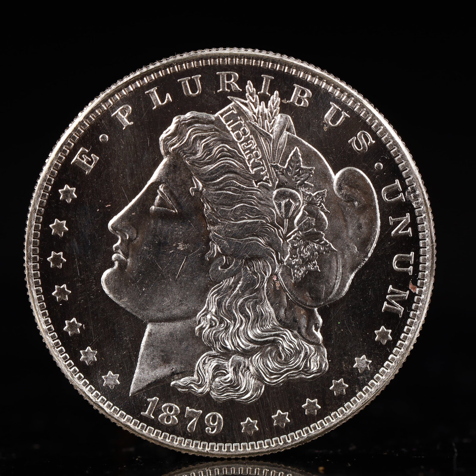 USA Morgan Dollar 1879 Coin: Obv: profile bust with date below and E PLURIBUS UNUM legend and stars around. Rev: eagle with In God we trust above within wreath with UNITED STATES OF AMERICA ONE DOLLAR legend. IN GOD WE TRUST / LI