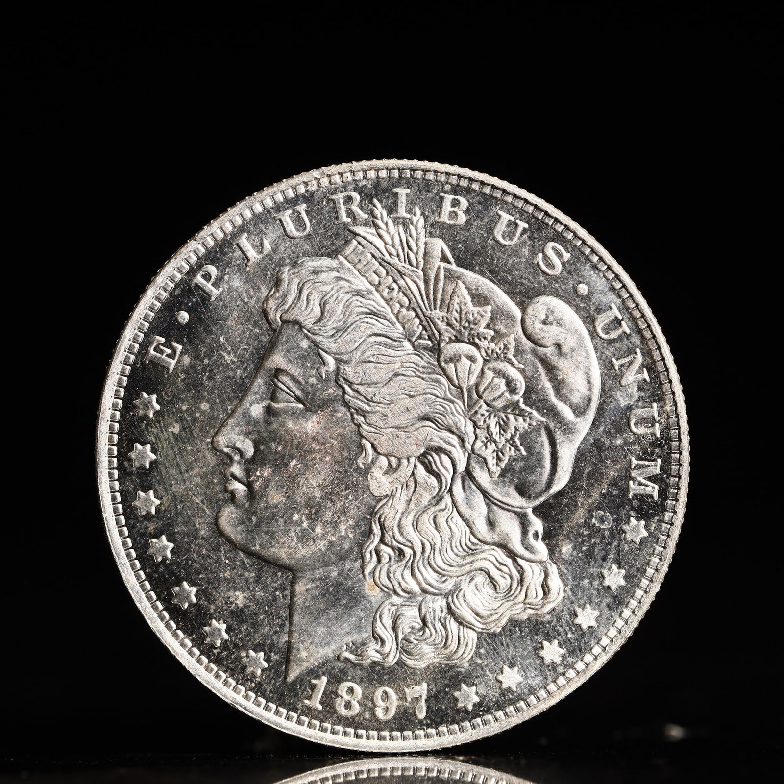 USA Morgan Dollar 1897 Coin: Obv: profile bust with date below and E PLURIBUS UNUM legend and stars around. Rev: eagle with In God we trust above within wreath with UNITED STATES OF AMERICA ONE DOLLAR legend. IN GOD WE TRUST / LI