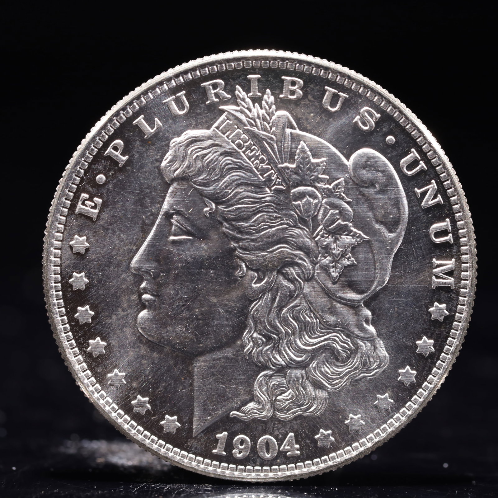 USA Morgan Dollar 1904 Coin: Obv: profile bust with date below and E PLURIBUS UNUM legend and stars around. Rev: eagle with In God we trust above within wreath with UNITED STATES OF AMERICA ONE DOLLAR legend. IN GOD WE TRUST / LI