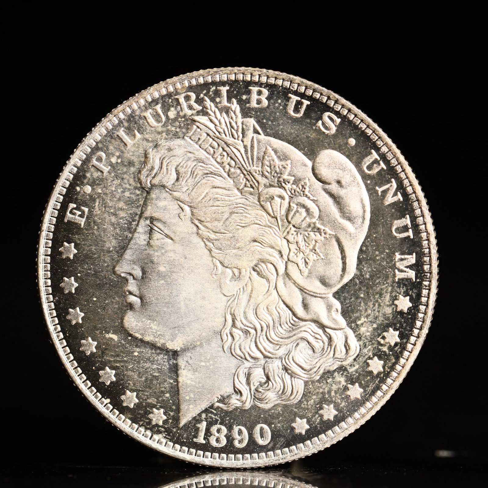 USA Morgan Dollar 1890 Coin: Obv: profile bust with date below and E PLURIBUS UNUM legend and stars around. Rev: eagle with In God we trust above within wreath with UNITED STATES OF AMERICA ONE DOLLAR legend. IN GOD WE TRUST / LI