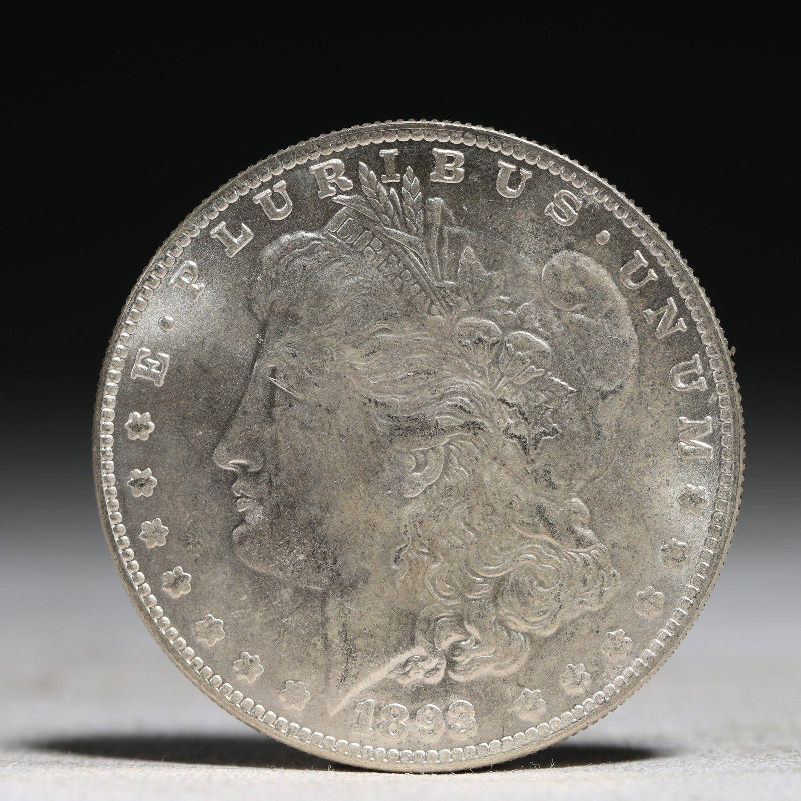 USA Morgan Dollar 1893 Coin: Obv: profile bust with date below and E PLURIBUS UNUM legend and stars around. Rev: eagle with In God we trust above within wreath with UNITED STATES OF AMERICA ONE DOLLAR legend. IN GOD WE TRUST / LI