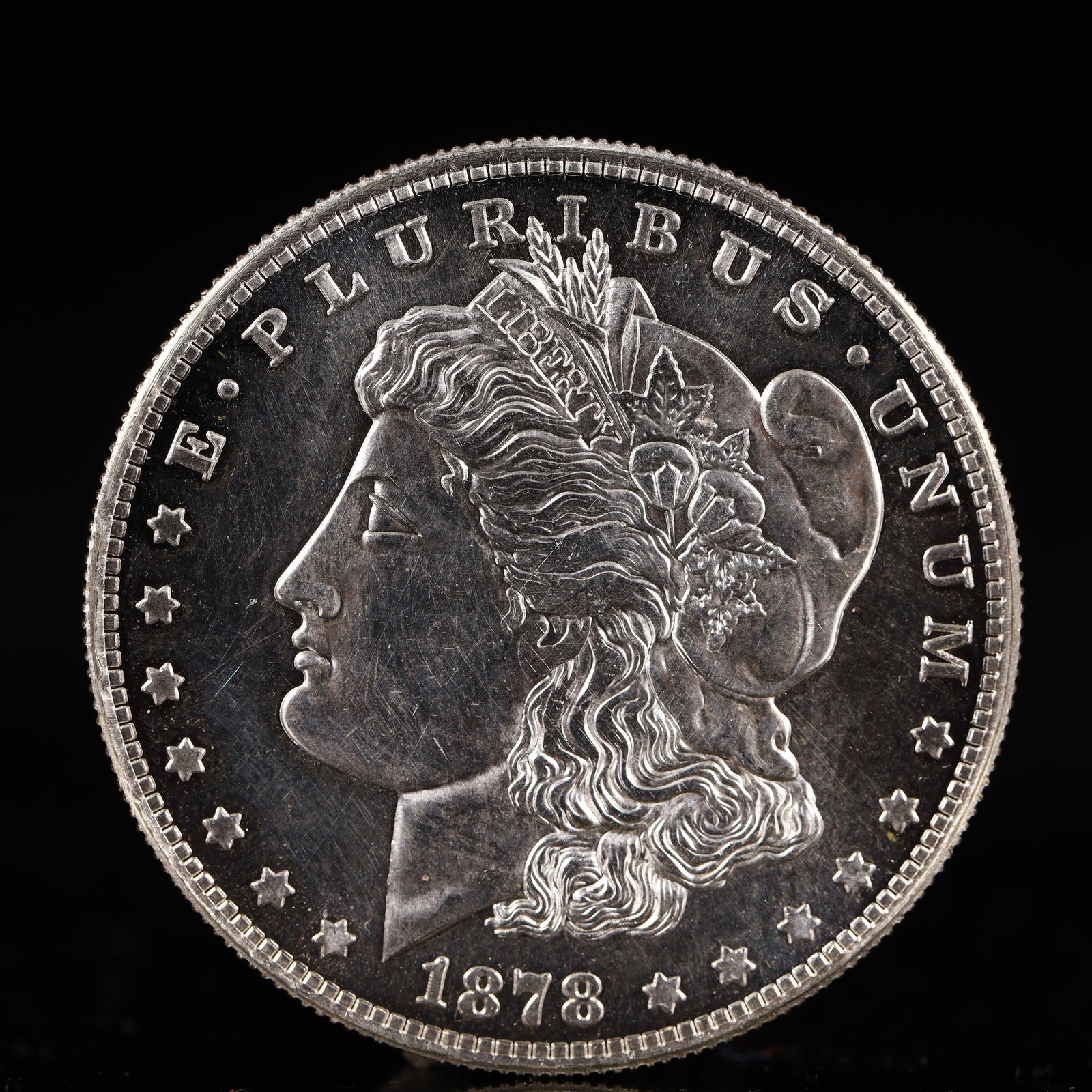 USA Morgan Dollar 1878 Coin: Obv: profile bust with date below and E PLURIBUS UNUM legend and stars around. Rev: eagle with In God we trust above within wreath with UNITED STATES OF AMERICA ONE DOLLAR legend. IN GOD WE TRUST / LI