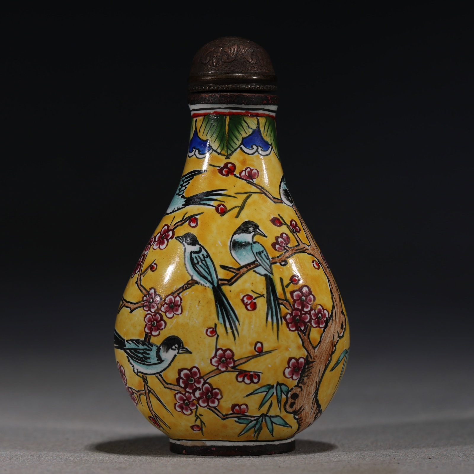 A Chinese Yellow-Ground Painted Enamel Snuff Bottle with Horses,Yide Cheng Mark: A Chinese yellow-ground painted enamel snuff bottle,decorated with a continuous scene of horses grazing in a landscape.Fitted with a red stopper.The base bears a four-character mark reading Yide Cheng