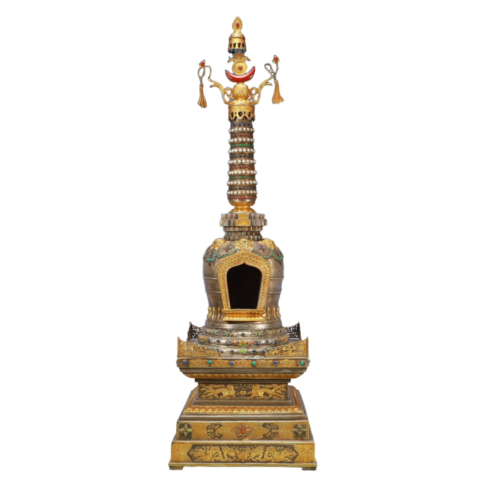A Solemn Gilt Bronze Statue of Avalokitesvara: A large gilt-silver shrine in the form of a palatial niche, meticulously chiselled with lotus scrolls and apsaras, the surface set with rubies, sapphires and turquoises. The base engraved with a four-