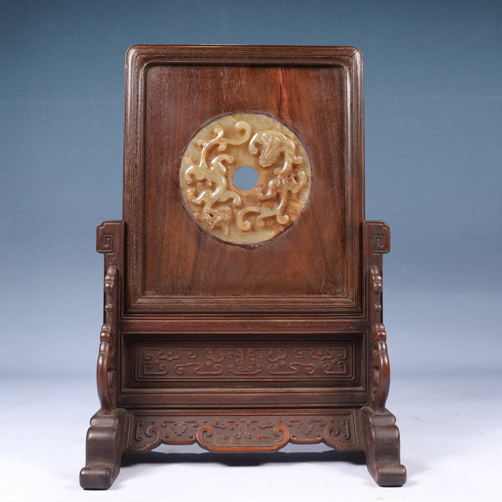 An Exquisite White Jade Maitreya Buddha Pendant: A fine table screen with a Huanghuali wood frame and stand, the central panel inlaid with a white jade openwork carving of two interlocking chi-dragons. The wood of rich grain and the jade of pure whi