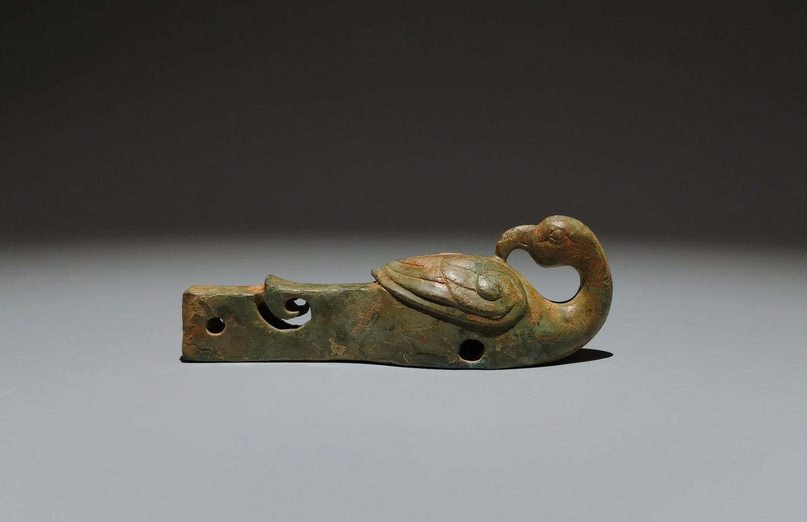 A Set of Exquisite Longquan yao Celadon Lotus Leaf Cup: A cast-bronze pendant in the form of a bird with outstretched wings and long tail feathers, the surface with a natural malachite-green patina. The simplified form conveys a strong archaic charm.