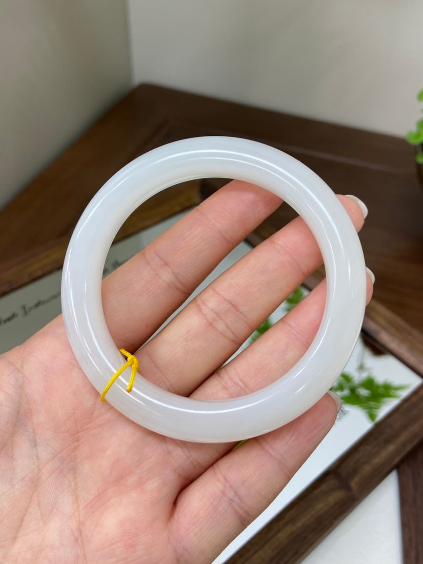 A Set of Fine White Jade Beast Pattern Swords: A fine Hetian jade bangle of 'noubo' (glutinous-icy) quality, of round form. The jade is of icy translucency with a warm, white, and glutinous texture, offering a refined and elegant appearance when w