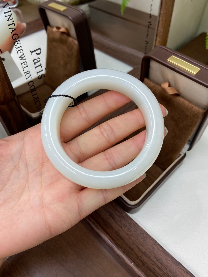 An Exquisite Black Ground Green Glazed Lotus Pattern Plate: A substantial Hetian jade bangle of Qiemo origin, of wide form. The jade is of fine, oily texture with a robust, substantial presence, offering a satisfying tactile experience when worn. The bangle