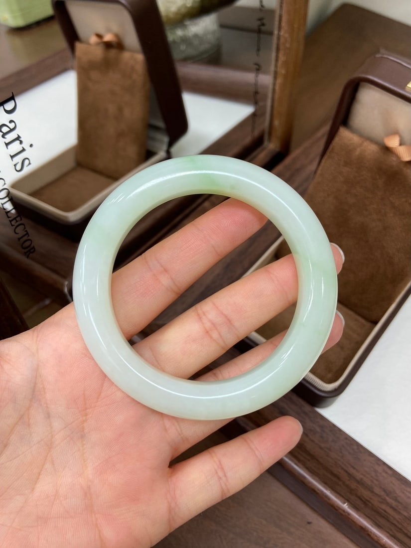 An Exquisite Famille-Rose Flower and Bird Pattern Vase,with poem: A fine Hetian jade bangle of 'cuiqing' (emerald-green) tone, of round form. The jade is of even, clean color with a plump, luxurious presence, exuding an air of sophistication. The bangle measures 57.