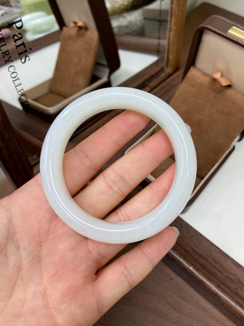 An Exquisite Famille-Rose Character and Story Pattern Vase,with poem: A finely carved Hetian jade bangle of 'yangzhi' (mutton-fat) white quality, of wide form. The jade is of fine, translucent texture with a high degree of jadeification, exuding a rich, oily luster.